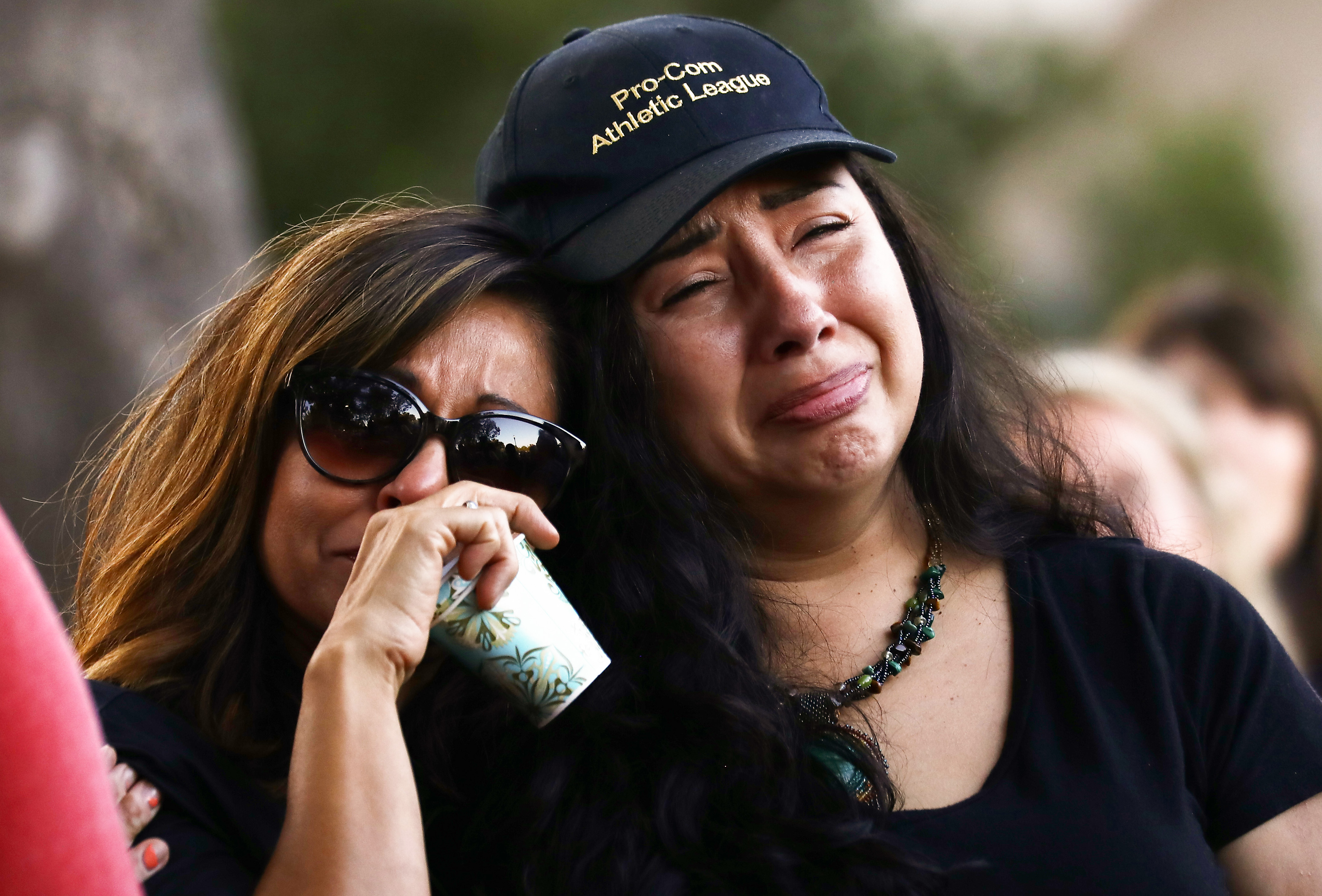 People embrace at a vigil for victims of the mass shooting at the Gilroy Garlic Festival on July 29, 2019 in Gilroy. (Credit: Mario Tama/Getty Images)