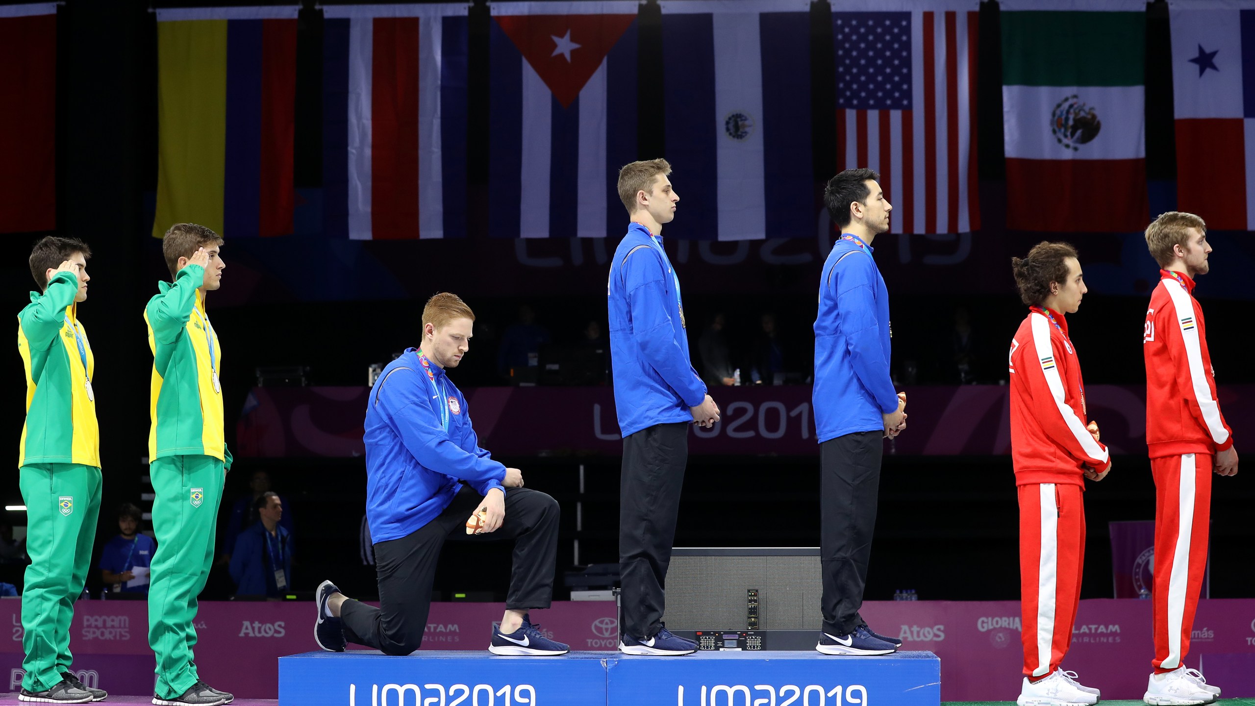 Gold medalist Race Imboden takes a knee during the national anthem ceremony in the 2019 Pan American Games at Fencing Pavilion of Lima Convention Center on Aug. 9, 2019 in Peru. (Credit: Leonardo Fernandez/Getty Images)