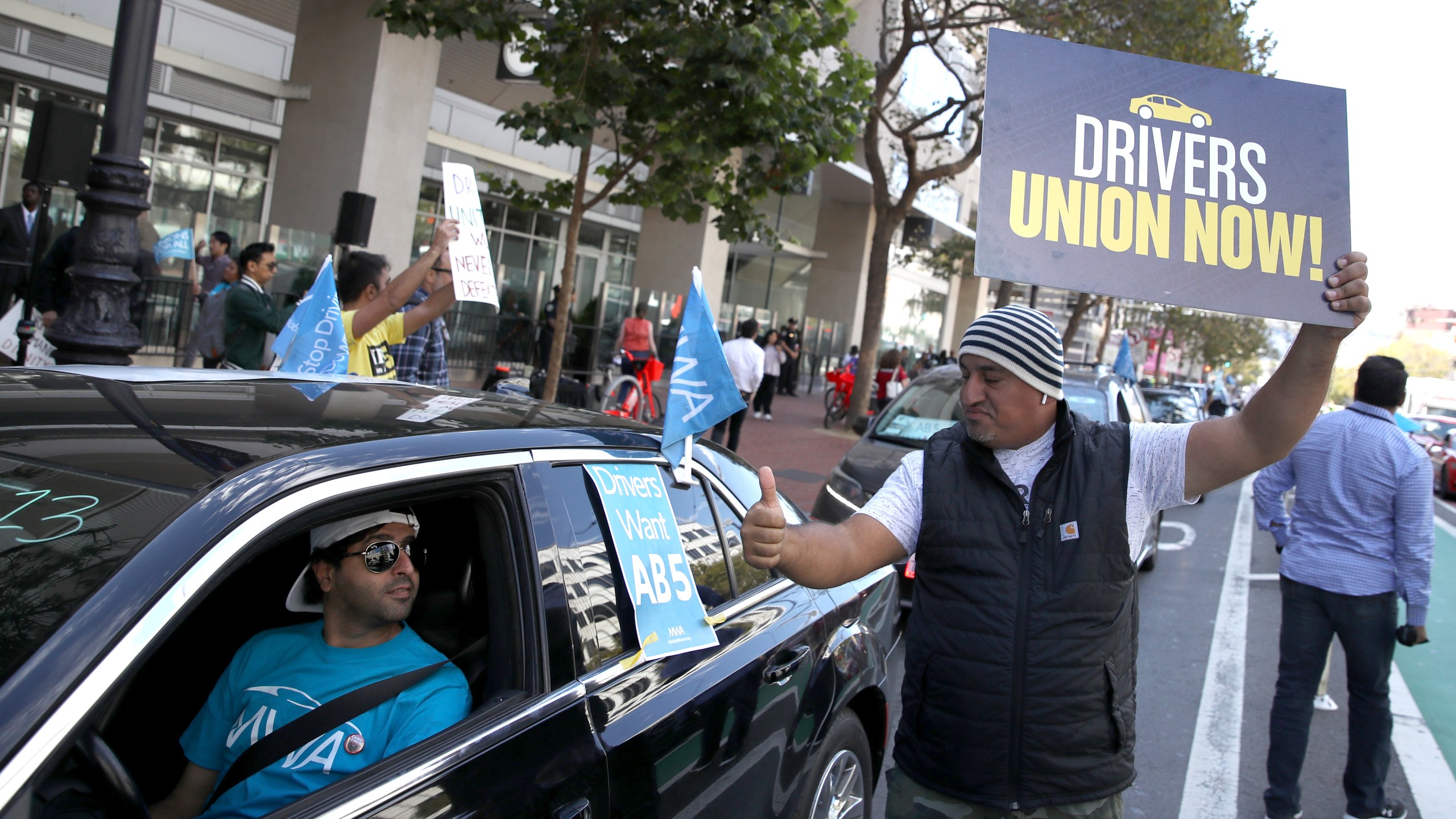 Ride-hailing app drivers hold signs during a protest outside of Uber headquarters in San Francisco on Aug. 27, 2019. (Credit: Justin Sullivan / Getty Images)