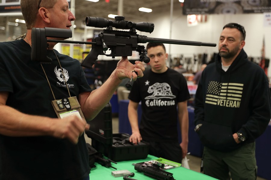 A gun seller demonstrates a firearm to potential buyers during the Nation's Gun Show on Nov. 18, 2016, at Dulles Expo Center in Chantilly, Virg. (Credit: Alex Wong/Getty Images)