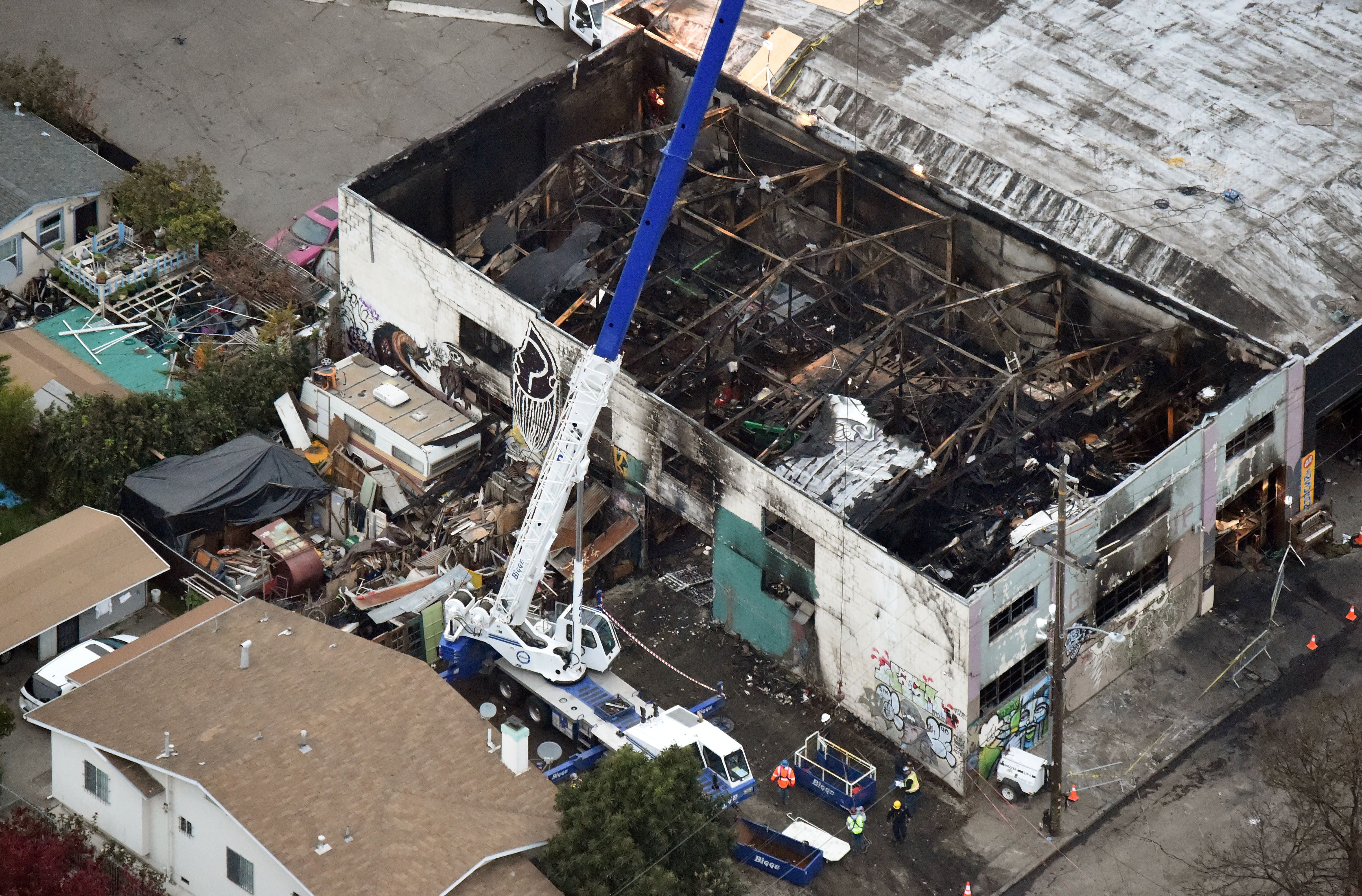 A crane is used to lift wreckage as part of search efforts in a fire-ravaged warehouse in Oakland on Dec. 5, 2016. (Credit: Josh Edelson / AFP / Getty Images)