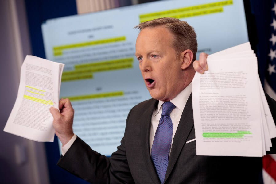 Sean Spicer holds up paperwork highlighting and comparing language about the National Security Council from the Trump administration and previous administrations during the daily press briefing at the White House, on Jan. 30, 2017 in Washington, D.C. (Credit: Drew Angerer/Getty Images)