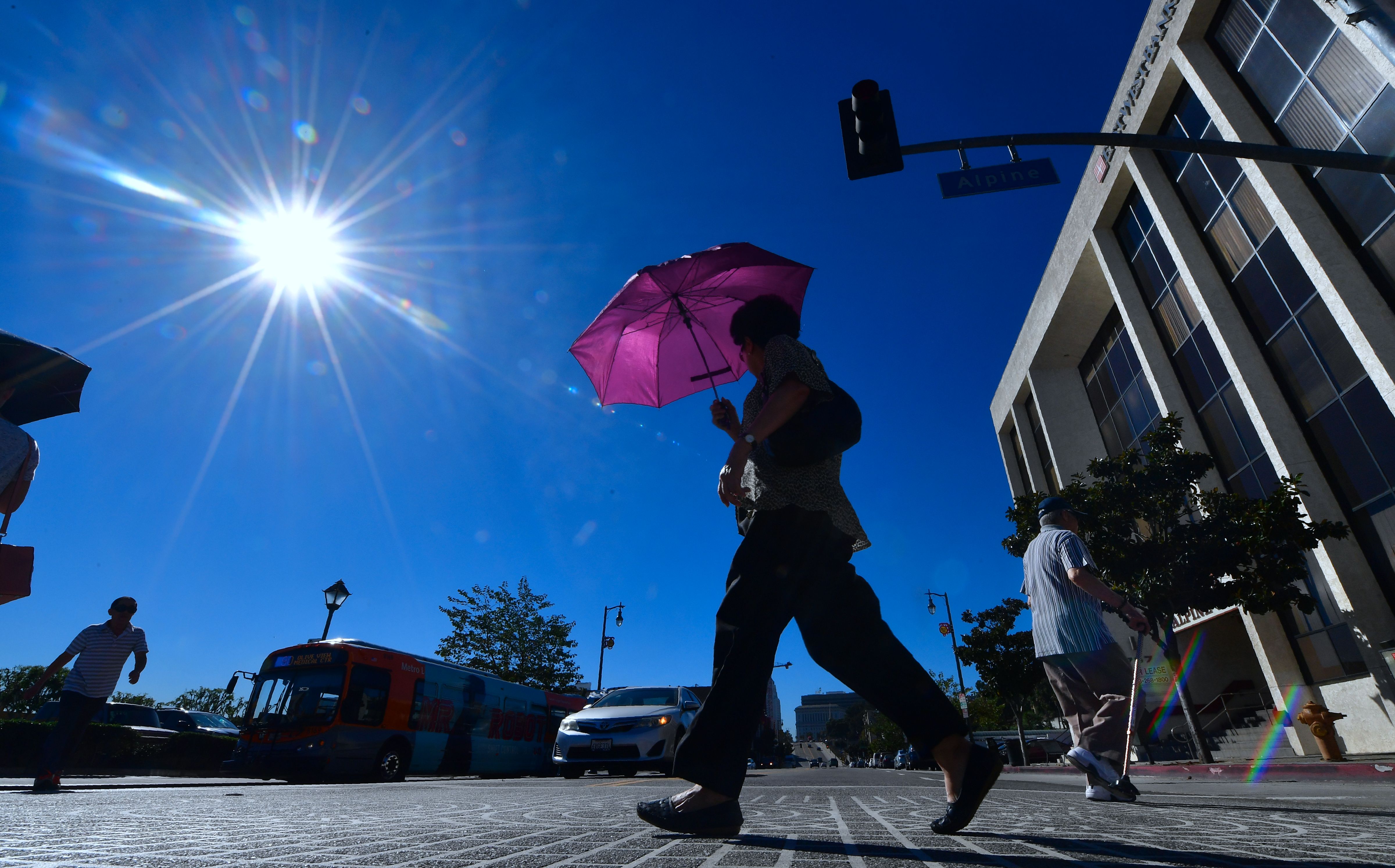 A pedestrian uses an umbrella on a hot sunny morning in Los Angeles Oct. 24, 2017, amid a late season heatwave hitting Southern California. (FREDERIC J. BROWN/AFP/Getty Images)