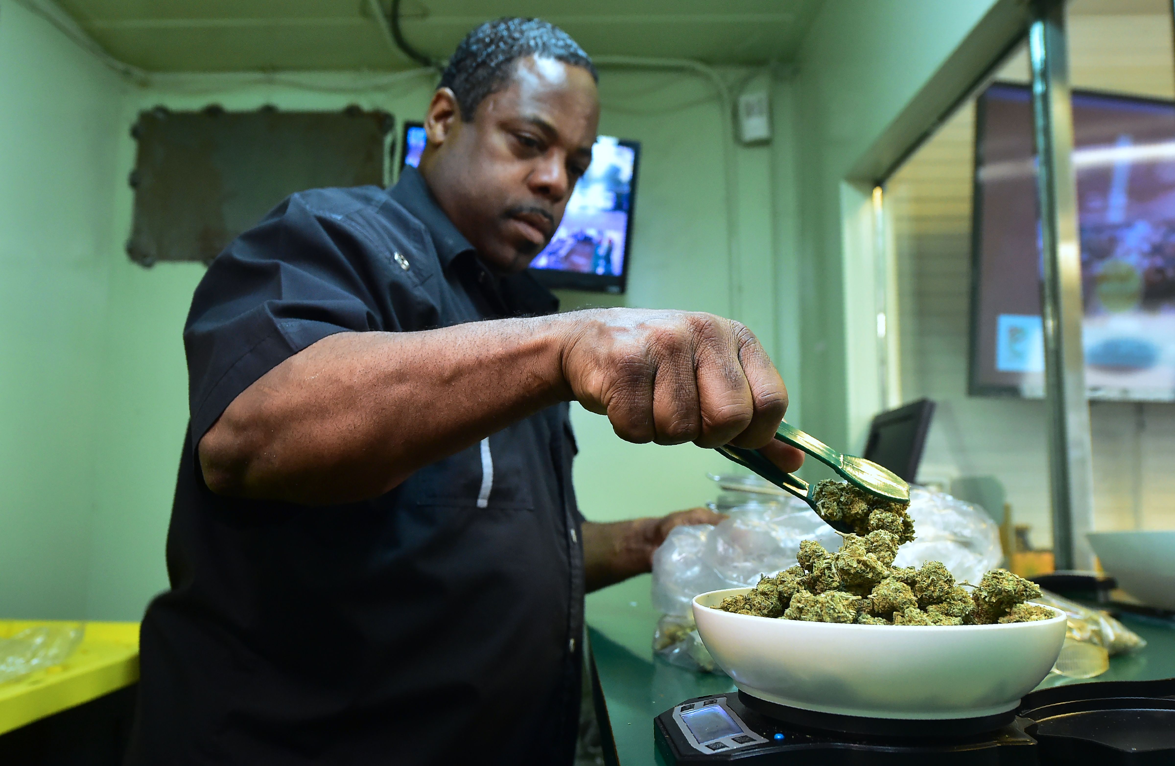 Eddie Irby weighs the marijuana at Virgil Grant's dispensary in Los Angeles, on Feb. 8, 2018. (Credit: FREDERIC J. BROWN/AFP/Getty Images)