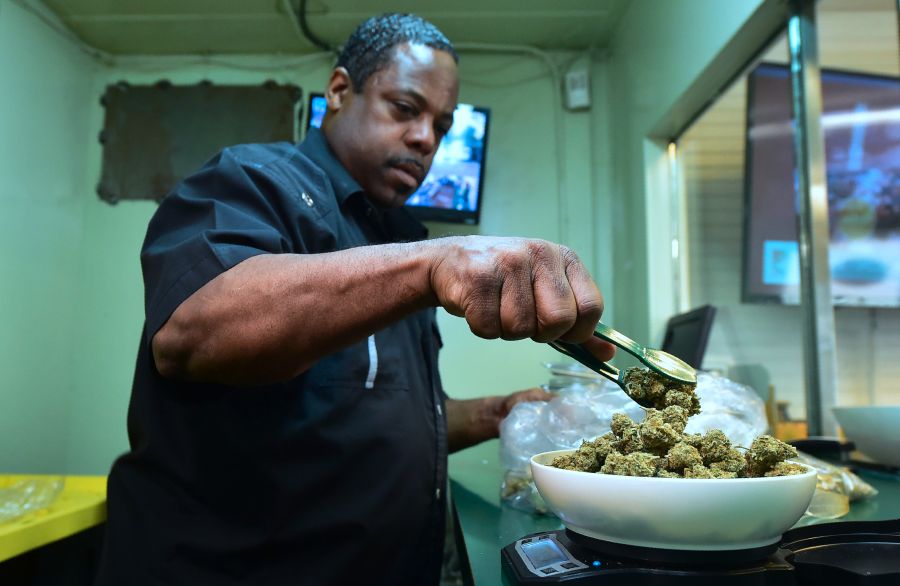 Eddie Irby weighs the marijuana at Virgil Grant's dispensary in Los Angeles, on Feb. 8, 2018. (Credit: FREDERIC J. BROWN/AFP/Getty Images)