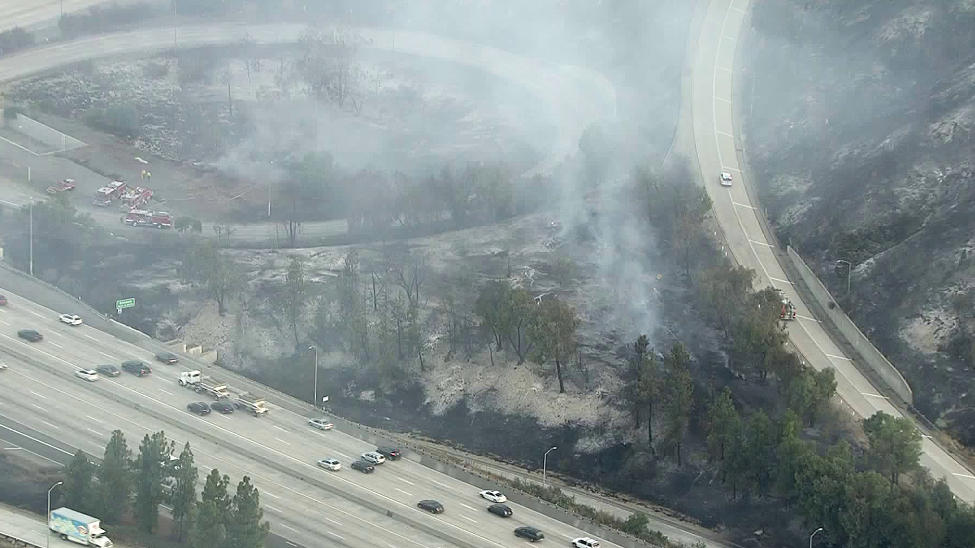 Smoke is seen near the 134 Freeway as fire crews work to control hot spots from a brush fire that broke out on Aug. 25, 2019. (Credit: KTLA)