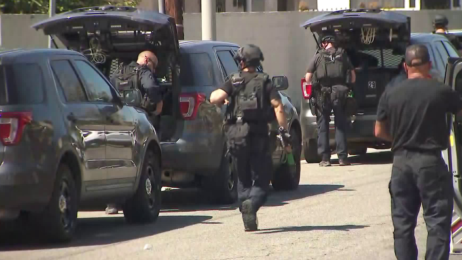 Uniformed officers walk through the scene in the South Los Angeles neighborhood of Vermont Knolls, where a person was fatally shot, on Aug. 29, 2019. (Credit: KTLA)