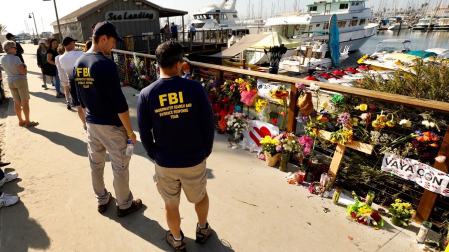 Members of an FBI dive team look at a growing memorial to the victims of the Labor Day fire aboard the Conception, a dive boat that was anchored off Santa Cruz Island. (Al Seib/Los Angeles Times)