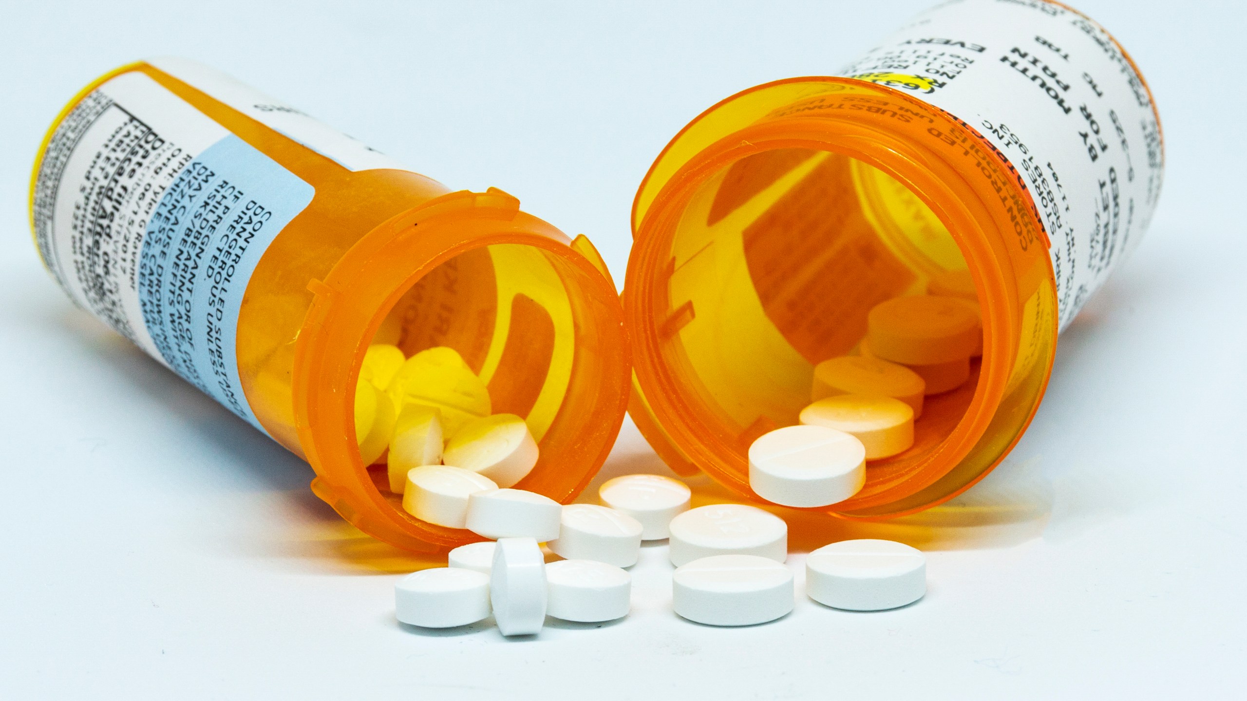 Pills spill out of two prescription bottles. (Getty Images)