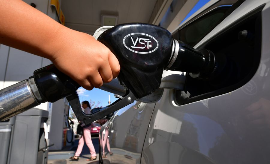 A child pumps gas for his father at a gas station in Los Angeles on April 9, 2019. (Credit: FREDERIC J. BROWN/AFP/Getty Images)