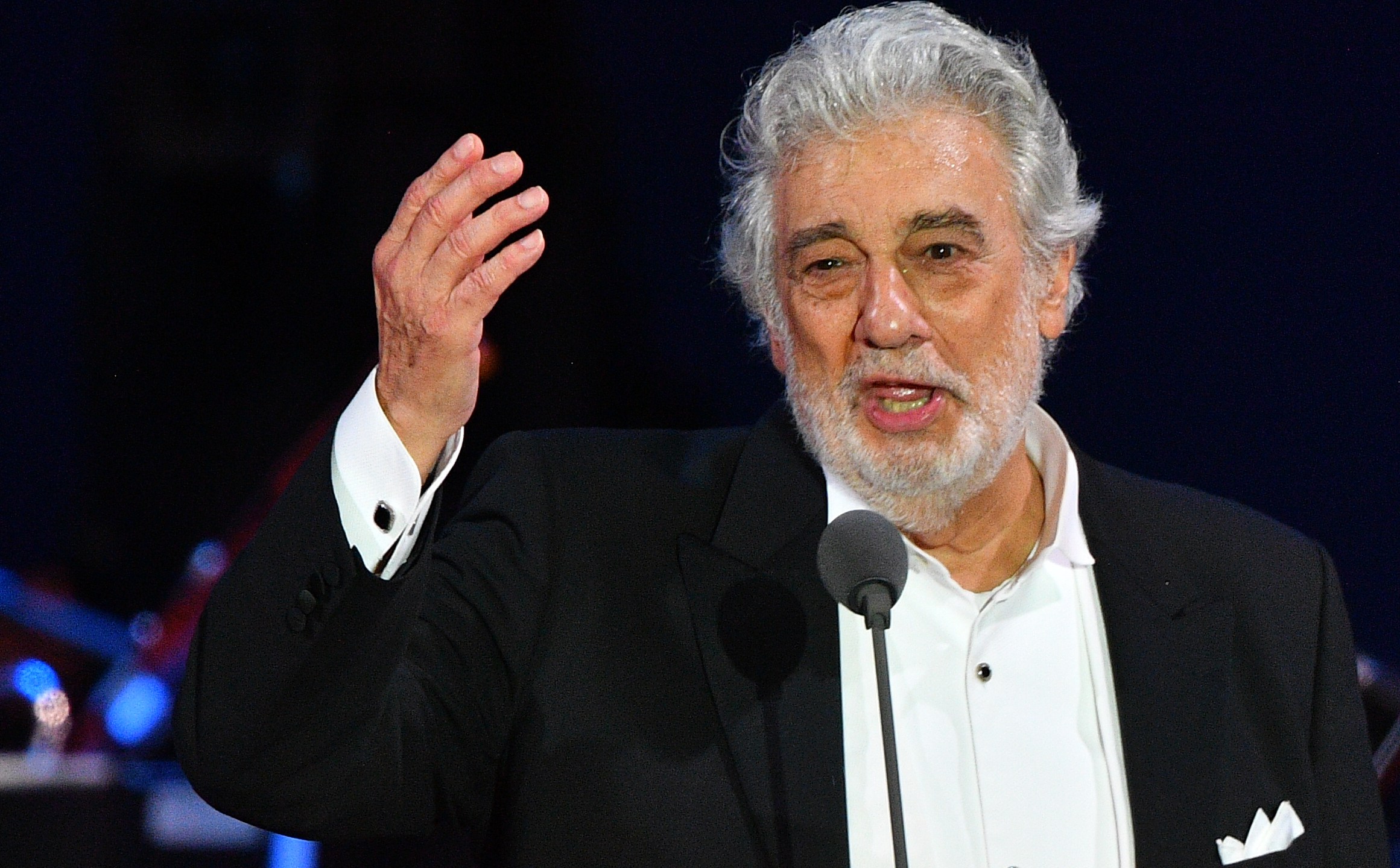 Spanish tenor Placido Domingo gestures as he performs during his concert in the newly inaugurated sports and culture centre 'St Gellert Forum' in Szeged, southern Hungary, on Aug. 28, 2019. (Credit: ATTILA KISBENEDEK/AFP/Getty Images)