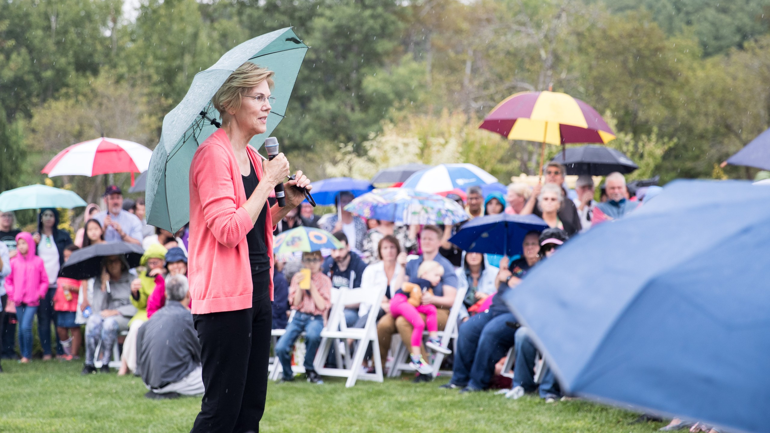 Sen. Elizabeth Warren speaks to a crowd of around 800 as it begins to rain during a Labor Day house party in Hampton Falls, New Hampshire, on Sept. 2, 2019. (Credit: Scott Eisen / Getty Images)