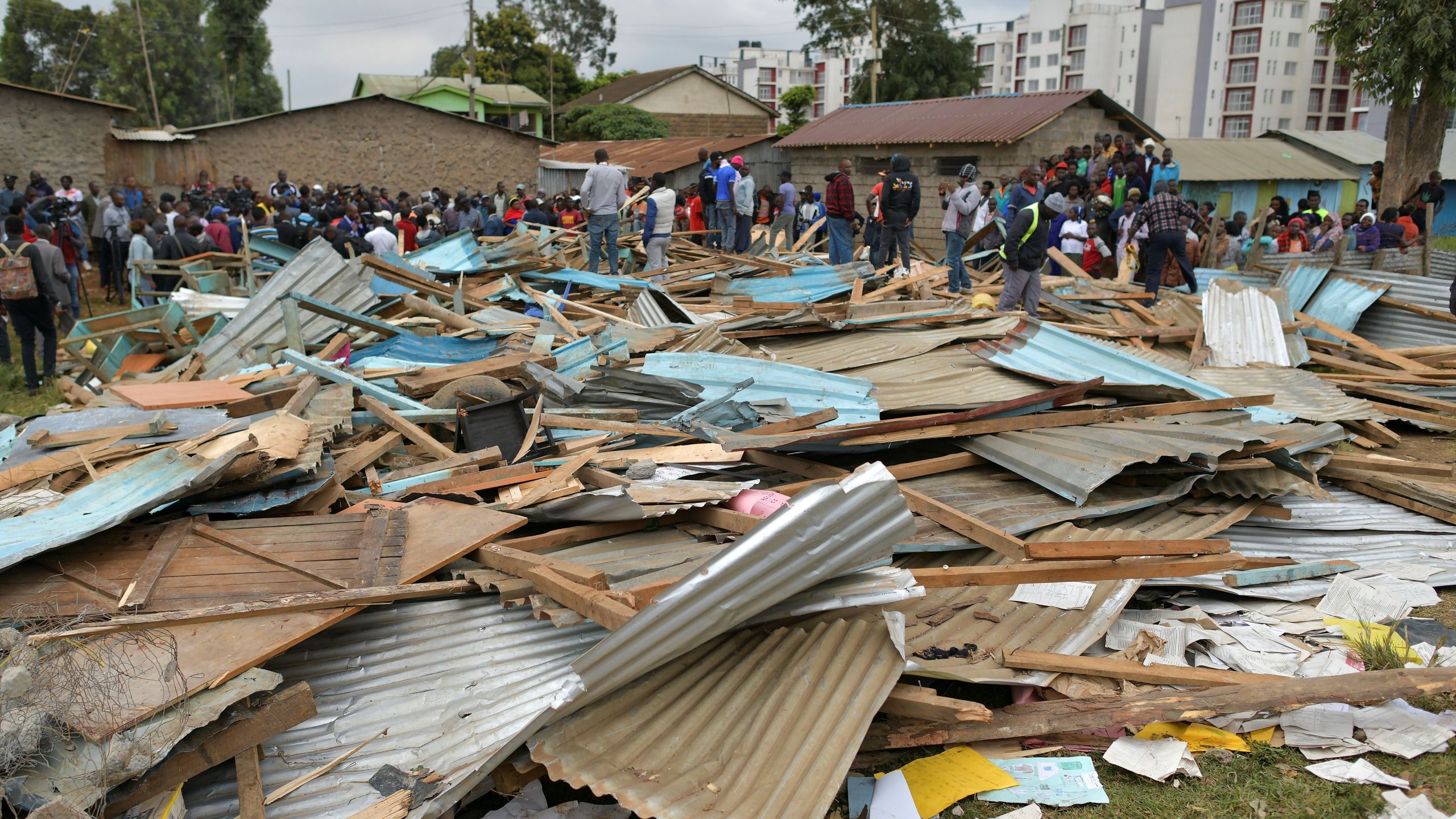 Relatives stand on debris of a collapsed school building, on September 23, 2019 in Nairobi. (Credit: TONY KARUMBA/AFP/Getty Images)