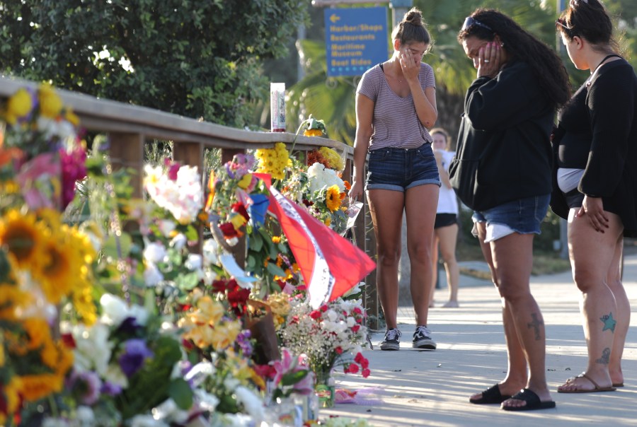 A woman stands in front of a makeshift memorial in Santa Barbara Harbor for victims of the Conception boat fire on Sept. 3, 2019. (Credit: Mario Tama/Getty Images)