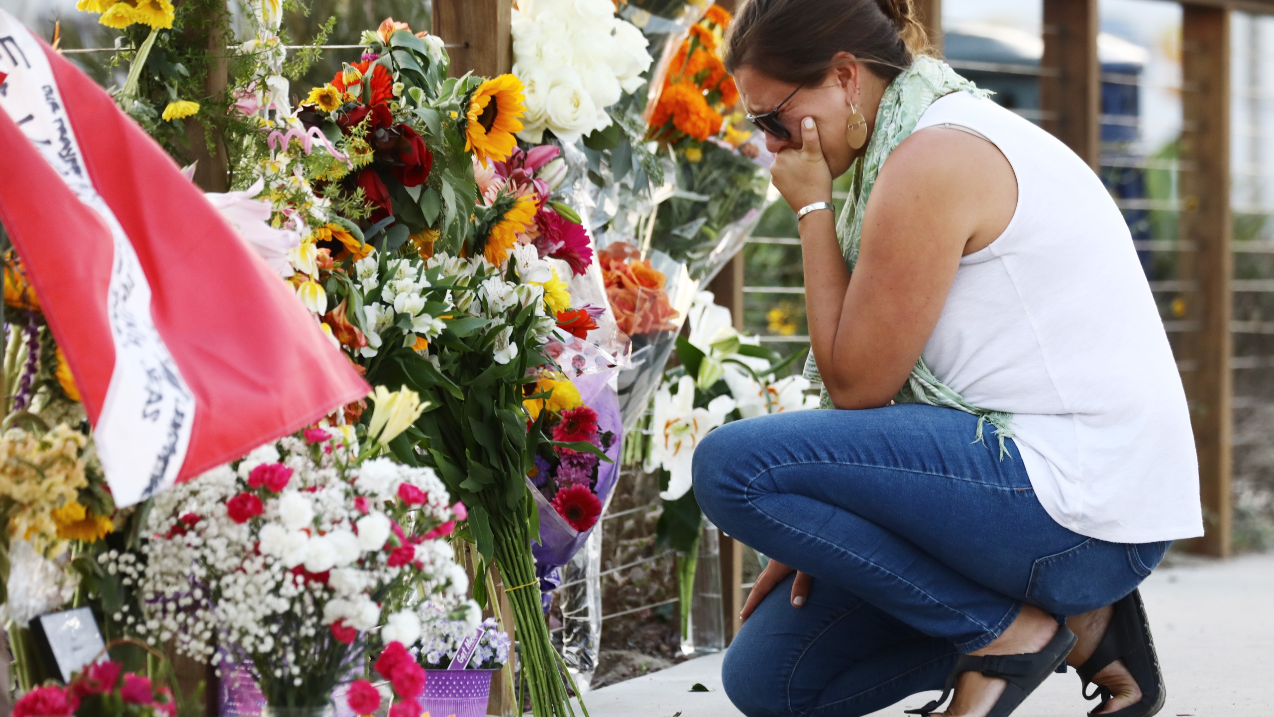 A woman looks emotional as she kneels at a makeshift memorial in Santa Barbara Harbor for victims of the Conception boat fire on Sept. 3, 2019, in Santa Barbara. (Credit: Mario Tama/Getty Images)