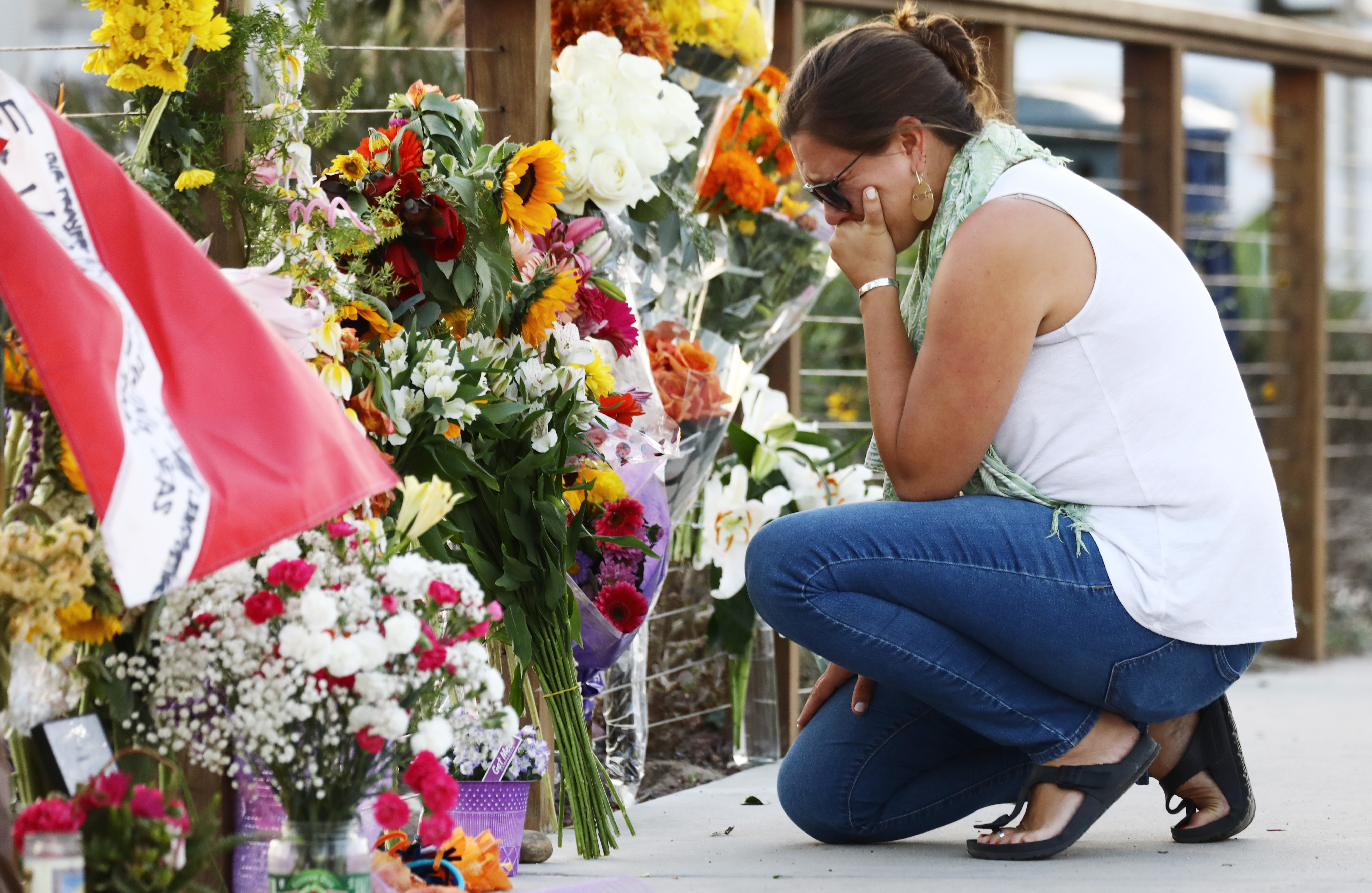 A woman looks emotional as she kneels at a makeshift memorial in Santa Barbara Harbor for victims of the Conception boat fire on Sept. 3, 2019, in Santa Barbara. (Credit: Mario Tama/Getty Images)