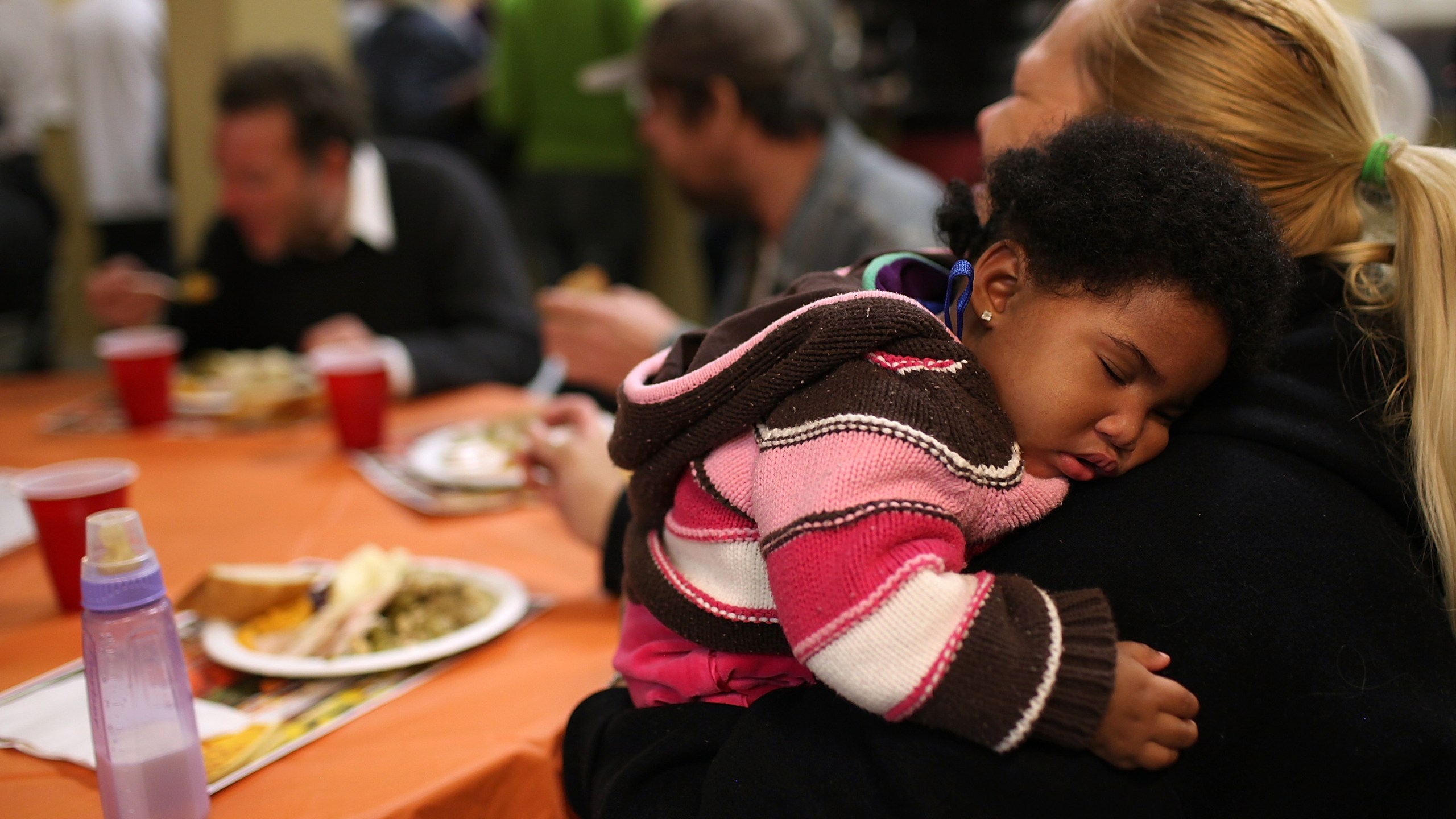 Eight month-old Canziz Lynch sleeps as people enjoy a free Thanksgiving meal at CityTeam Ministries on Nov. 23, 2011, in San Francisco. CityTeam Ministries in San Francisco fed nearly 400 Thanksgiving meals to homeless and underprivileged people that year. (Credit:Justin Sullivan/Getty Images)