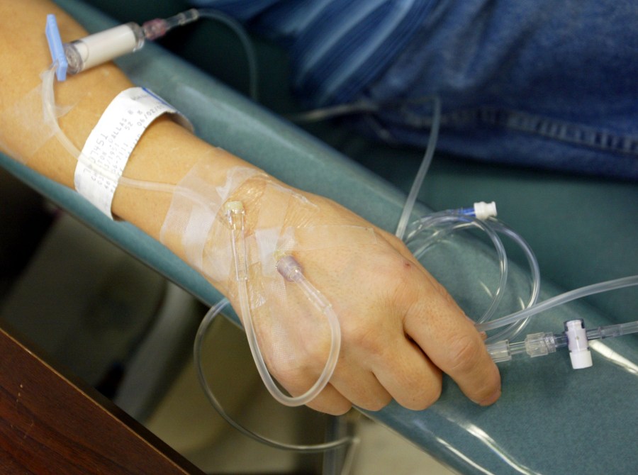 A cancer patient holds the tubes that funnel chemotherapy drugs into his body in this file photo. (Credit: Chris Hondros/Getty Images)