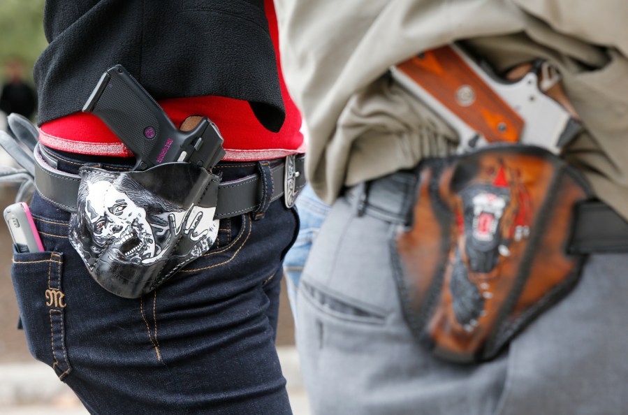 Art and Diana Ramirez of Austin with their pistols in custom-made holsters during an open-carry rally at the Texas State Capitol on Jan. 1, 2016 in Austin, Texas. (Credit: Erich Schlegel/Getty Images)