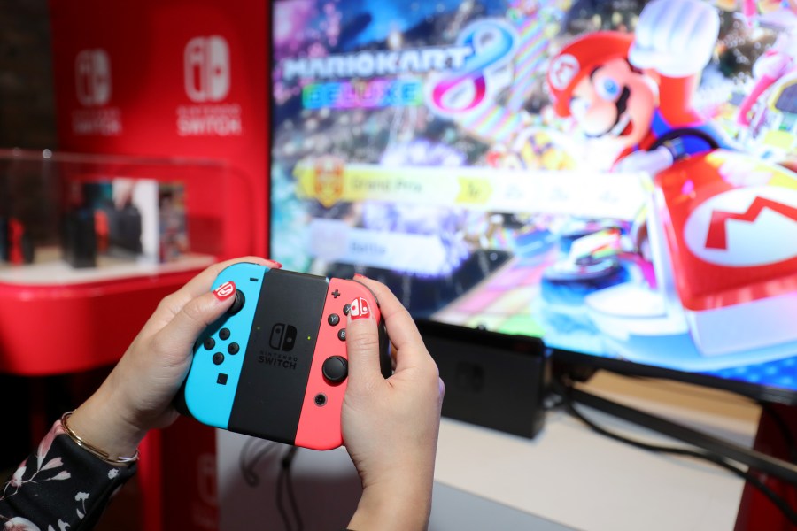 A guest enjoys playing Mario Kart 8 Deluxe on the new Nintendo Switch at a special preview event in New York on Jan. 13, 2017. Launching in March 3, 2017, Nintendo announced on Feb. 1, 2018, that Mario Kart will soon be available on mobile phones. (Credit: Neilson Barnard/Getty Images for Nintendo of America)