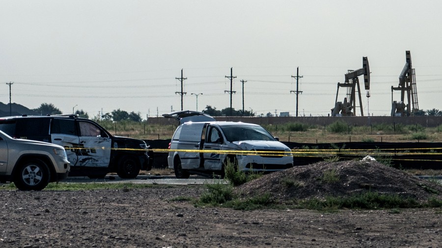 A damaged police vehicle and U.S. Postal Service van blocked off with tape nearby to where a gunman was shot and killed at Cinergy Odessa movie theater following a deadly shooting spree on September 1, 2019 in Odessa, Texas. (Credit: Cengiz Yar/Getty Images)