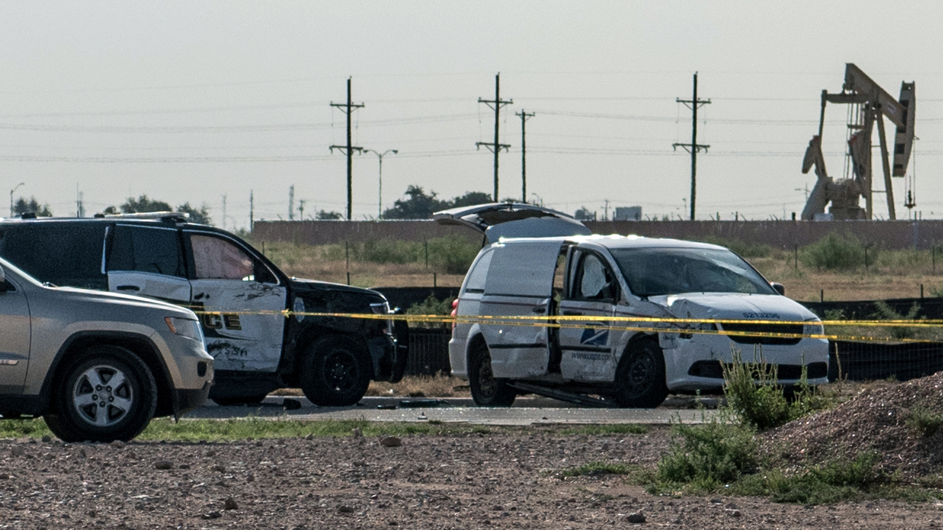 A damaged police vehicle and U.S. Postal Service van blocked off with tape nearby to where a gunman was shot and killed at Cinergy Odessa movie theater following a deadly shooting spree on September 1, 2019 in Odessa, Texas. (Credit: Cengiz Yar/Getty Images)