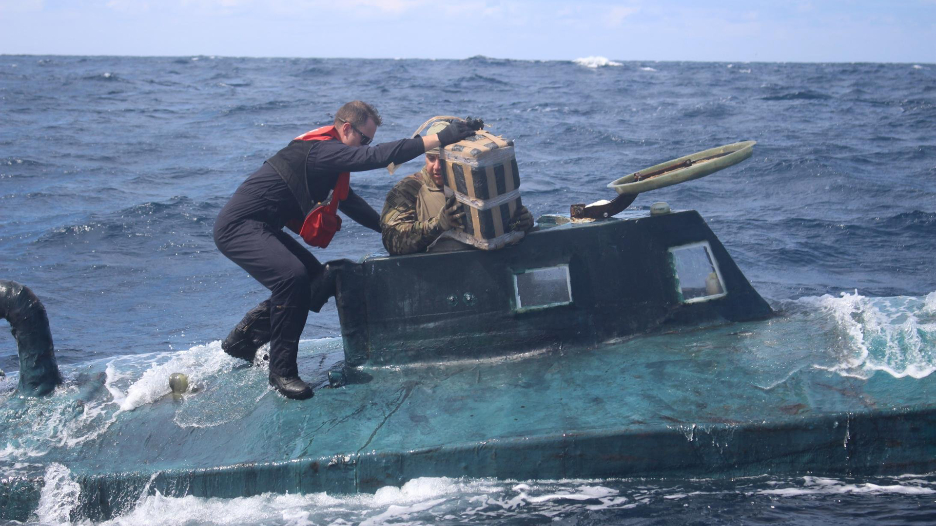 Coast Guard boarding team members climb aboard the 40-foot "narco sub." (Credit: U.S. Coast Guard District)