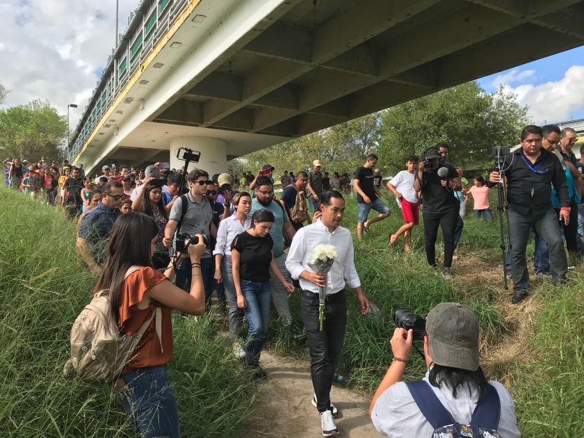 Julián Castro prepares to place flowers at crosses on the Rio Grande on Oct. 7, 2019 honoring migrants who died while attempting to reach the U.S. this year. Then he escorted 12 asylum seekers across the border bridge to the U.S. (Credit: Molly Hennessy-Fiske / Los Angeles Times )