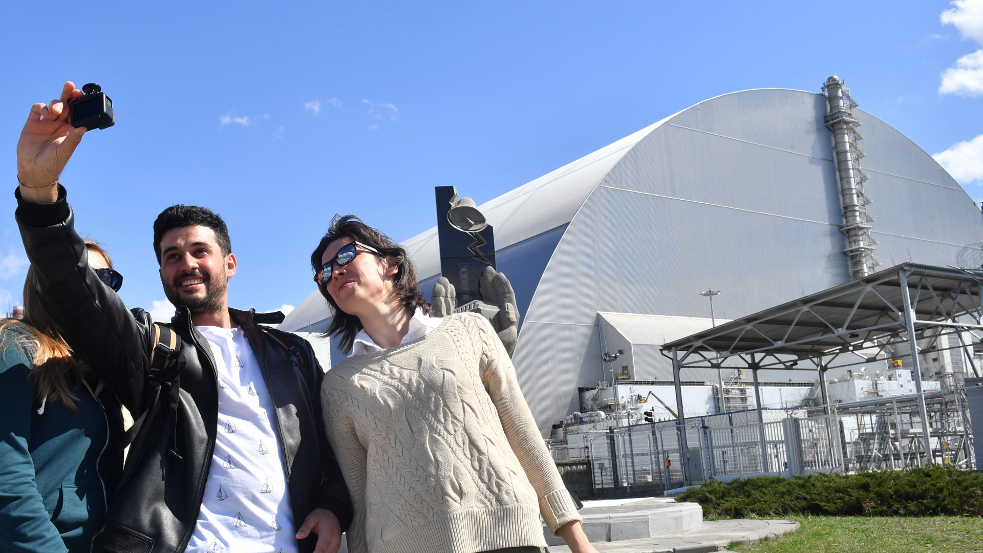 Tourists take pictures at Chernobyl's New Safe Confinement covering the 4th block of Chernobyl Nuclear power plant during their tour to the Chernobyl exclusion zone on April 23, 2018.(Credit: SERGEI SUPINSKY/AFP/Getty Images)