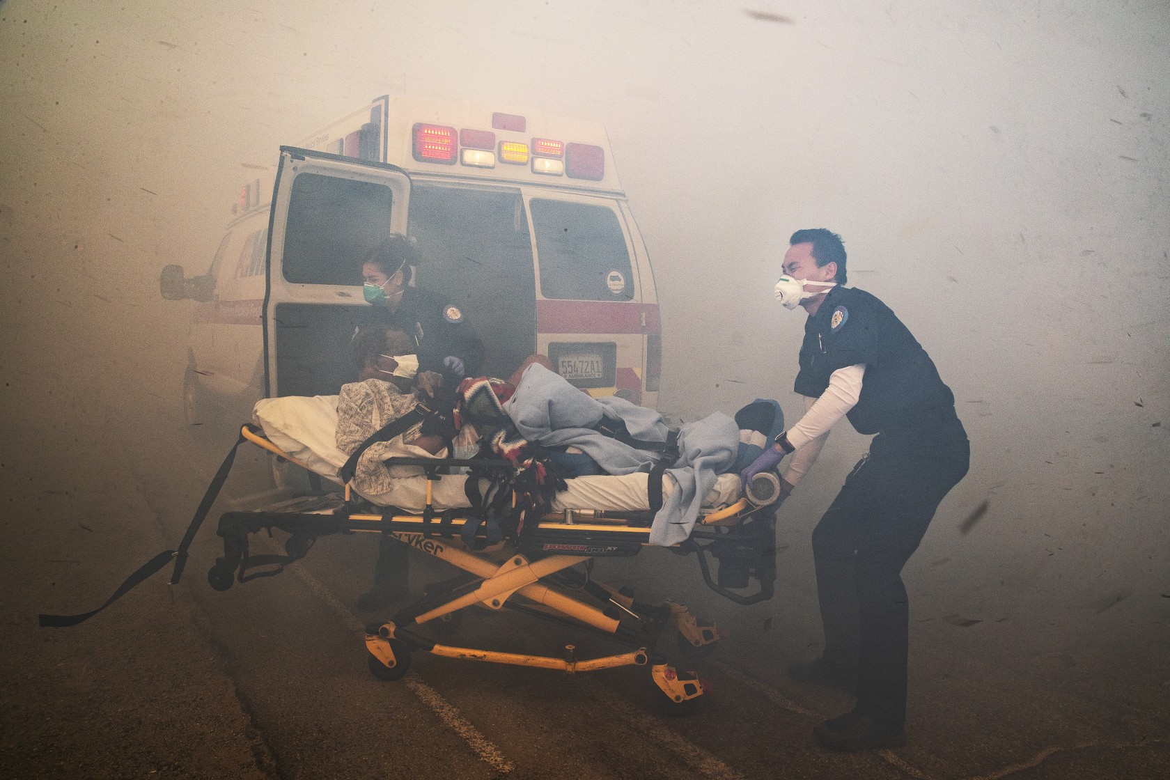 Paramedics battle thick smoke to evacuate a resident from the Riverside Heights Healthcare Center on Oct. 30 as the hill Fire burned dangerously close to the facility in Jurupa Valley. (Credit: Gina Ferazzi/ Los Angeles Times)