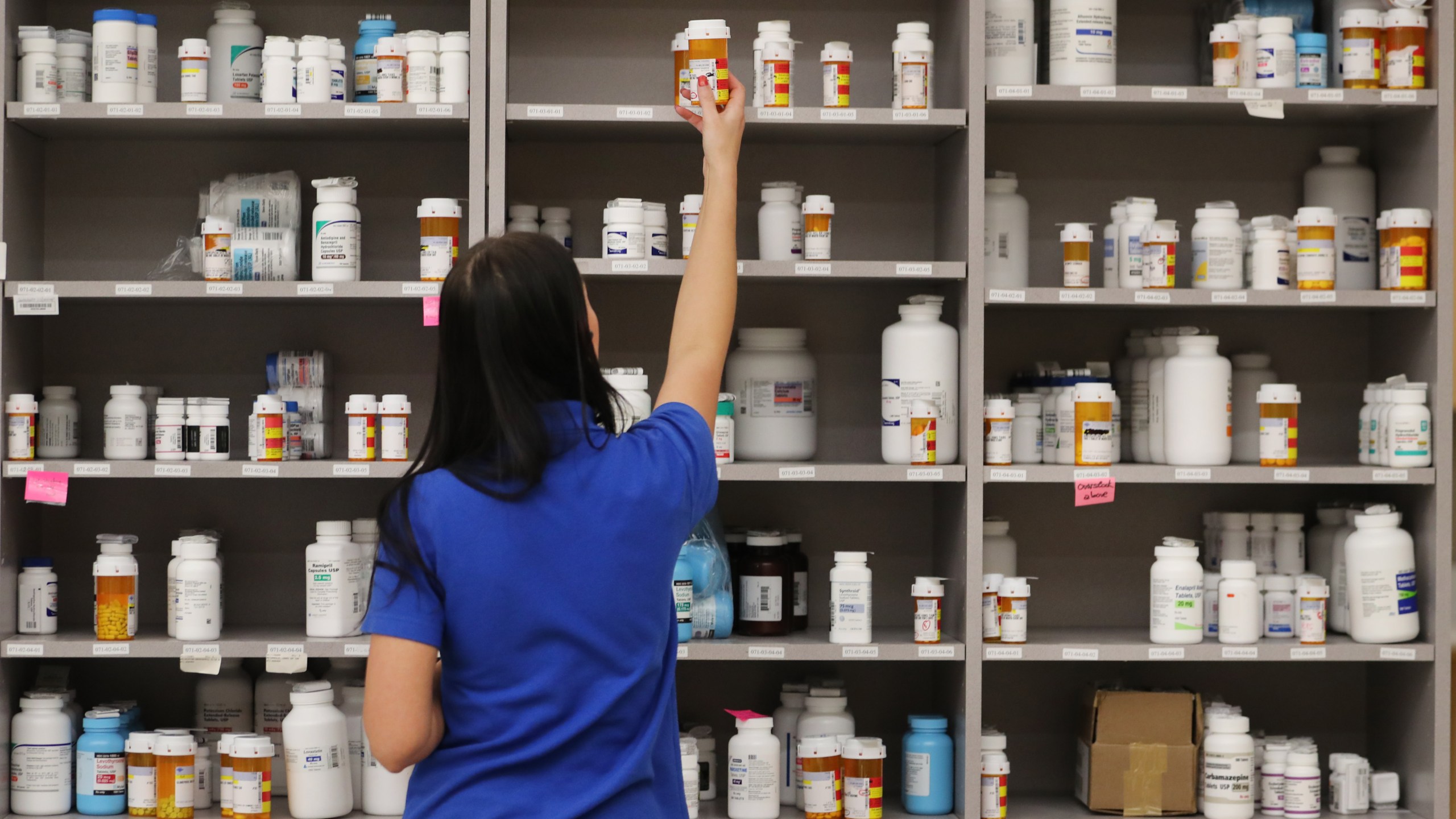 A pharmacy technician grabs a bottle of drugs off a shelve at the central pharmacy of Intermountain Heathcare on Sept. 10, 2018, in Midvale, Utah. (Credit: George Frey/Getty Images)