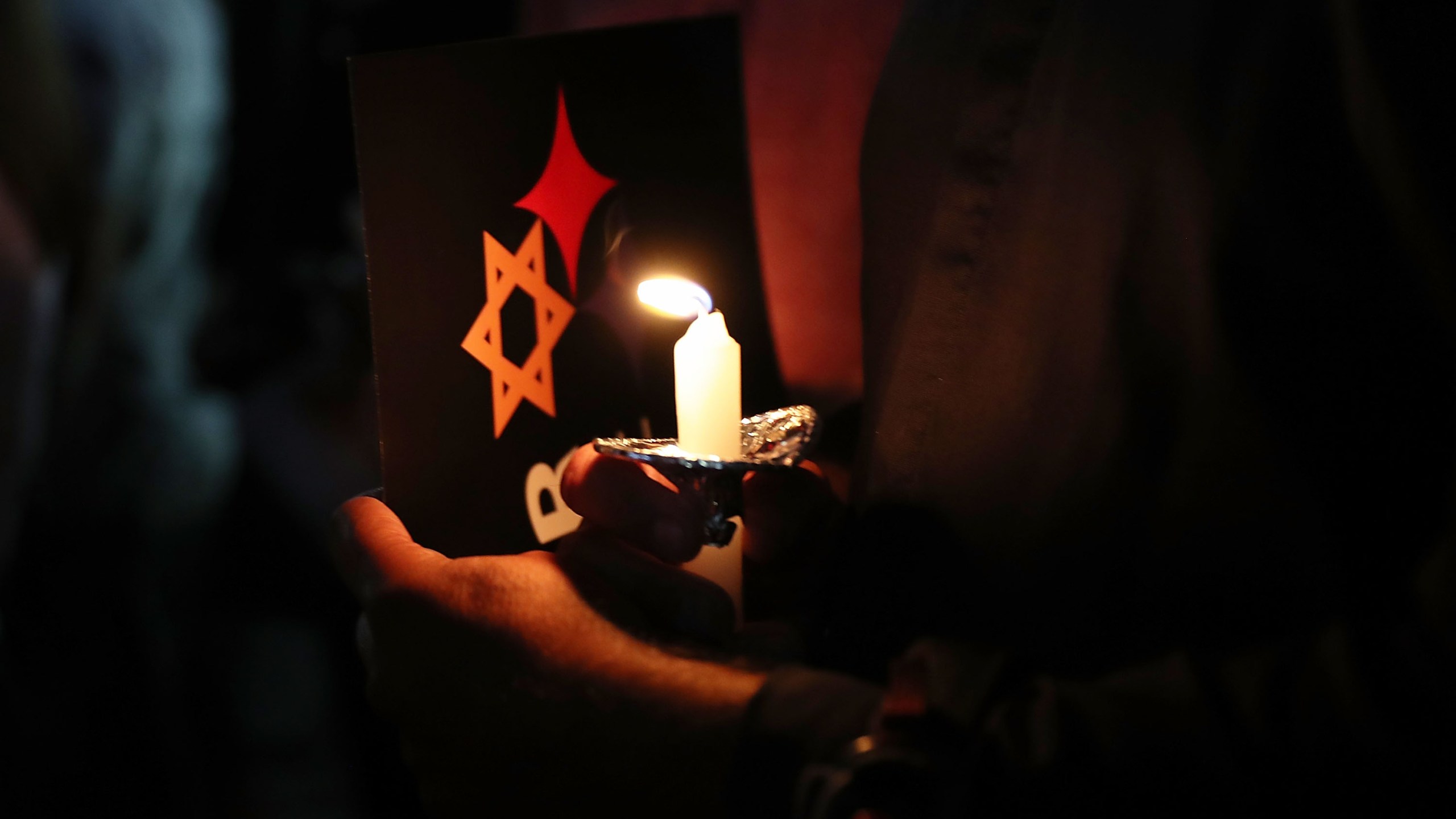 People hold candles as they gather together for a Community-Wide Solidarity Vigil at the Holocaust Memorial Miami Beach to remember the victims of the mass shooting at a Pittsburgh temple on Oct. 30, 2018 in Miami Beach, Fla. (Credit: Joe Raedle/Getty Images)