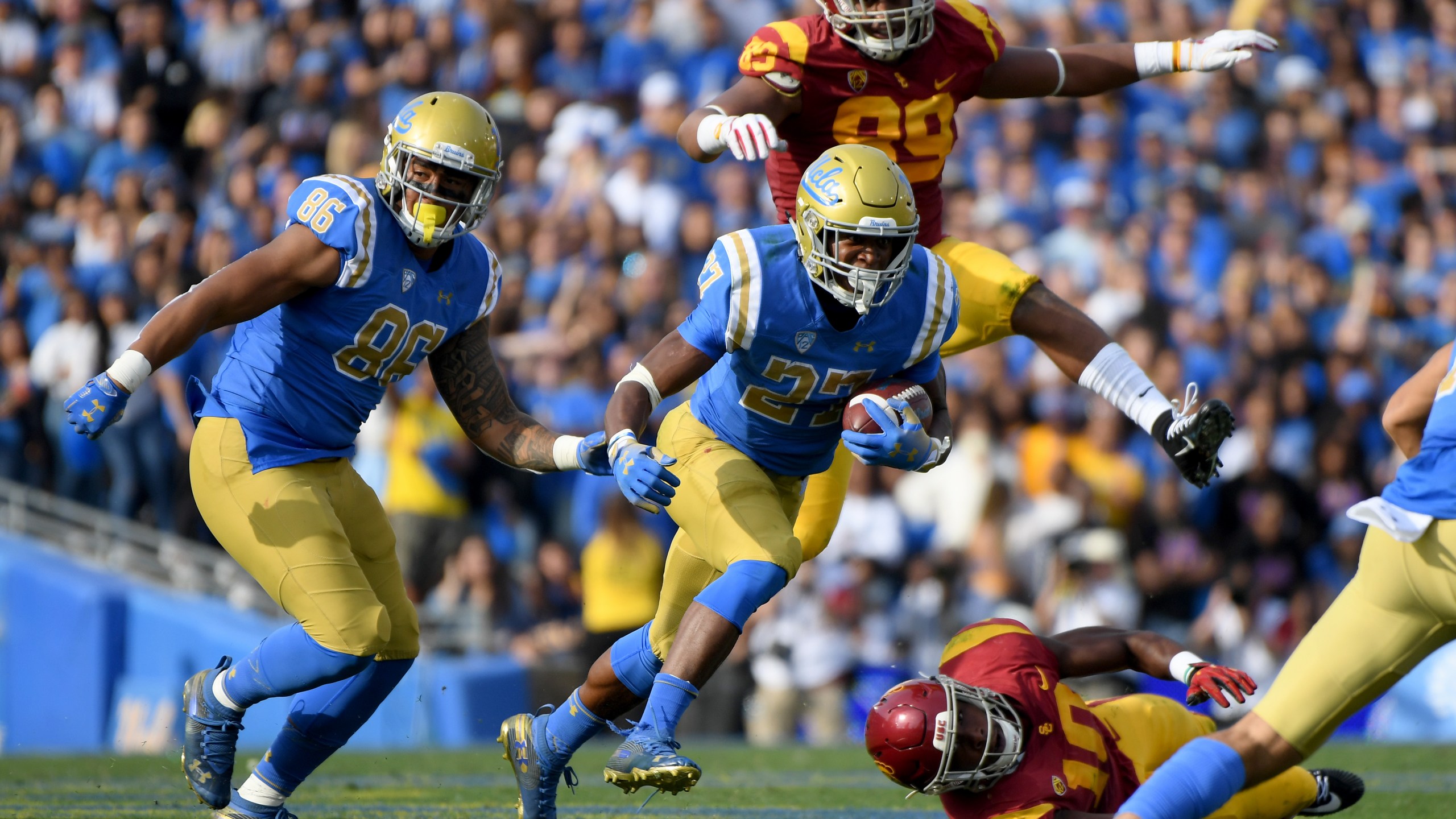 Joshua Kelley of the UCLA Bruins runs with Devin Asiasi during a match at the Rose Bowl on Nov. 17, 2018 in Pasadena. (Credit: Harry How/Getty Images)