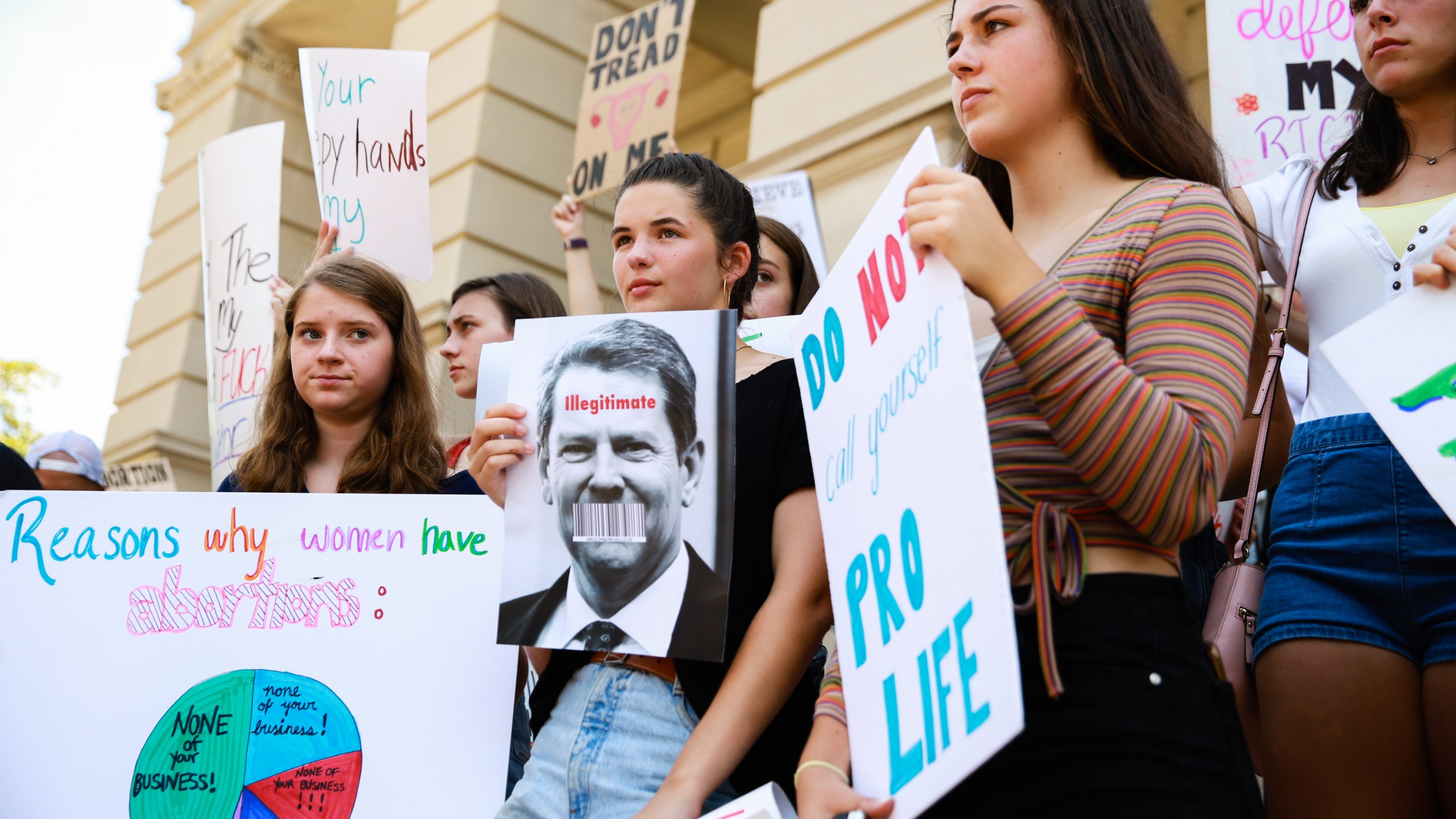 Young women from Paideia High School hold signs during a protest against recently passed abortion ban bills at the Georgia State Capitol building in Atlanta on May 21, 2019. (Credit: Elijah Nouvelage / Getty Images)