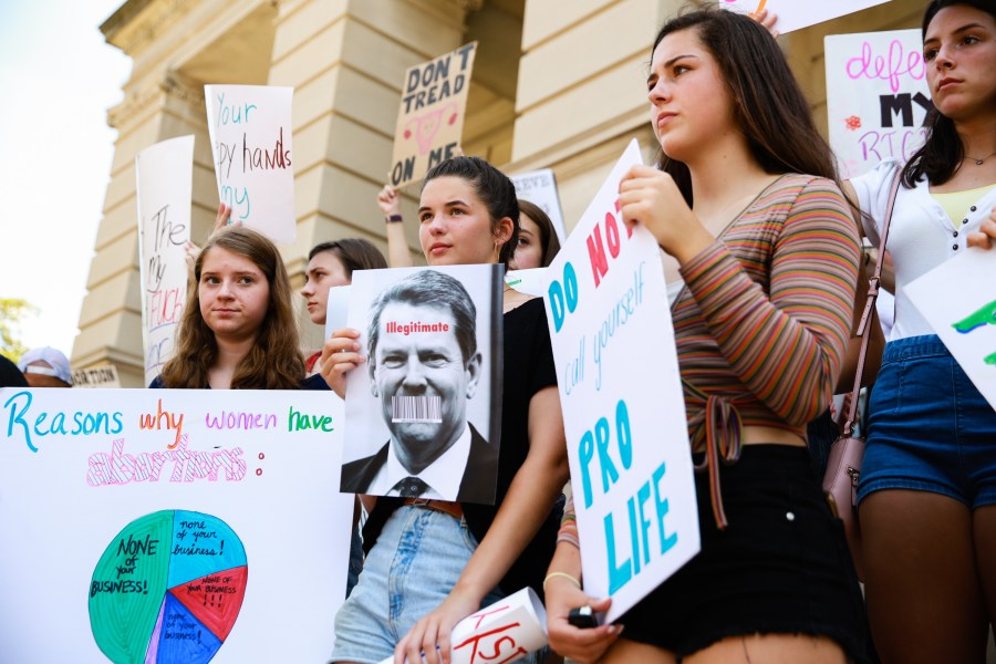 Young women from Paideia High School hold signs during a protest against recently passed abortion ban bills at the Georgia State Capitol building in Atlanta on May 21, 2019. (Credit: Elijah Nouvelage / Getty Images)