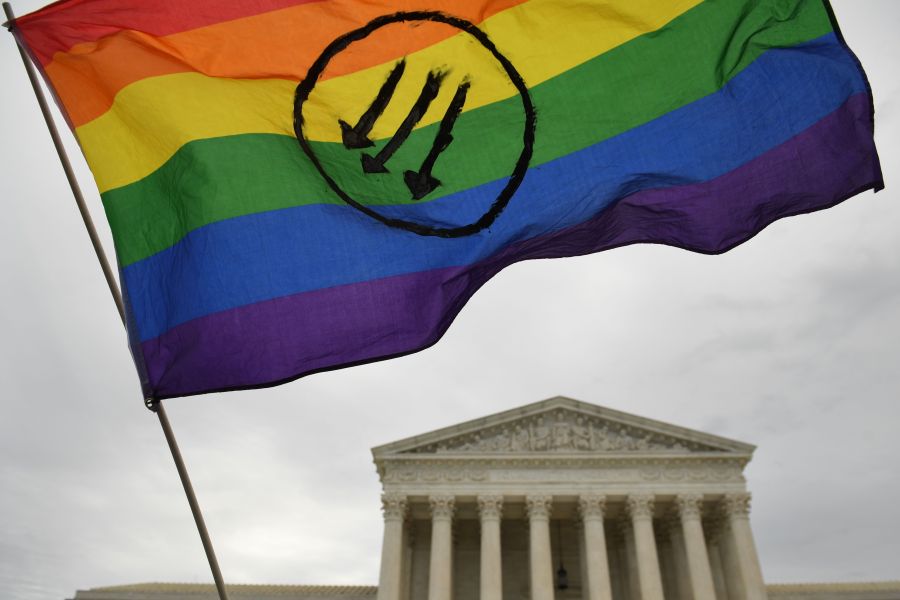 Demonstrators hold up a rainbow flag at an LGBT rights rally outside the U.S. Supreme Court in Washington, D.C., on Oct. 8, 2019, as the court holds oral arguments in cases dealing with workplace discrimination based on sexual orientation. (Credit: SAUL LOEB/AFP via Getty Images)