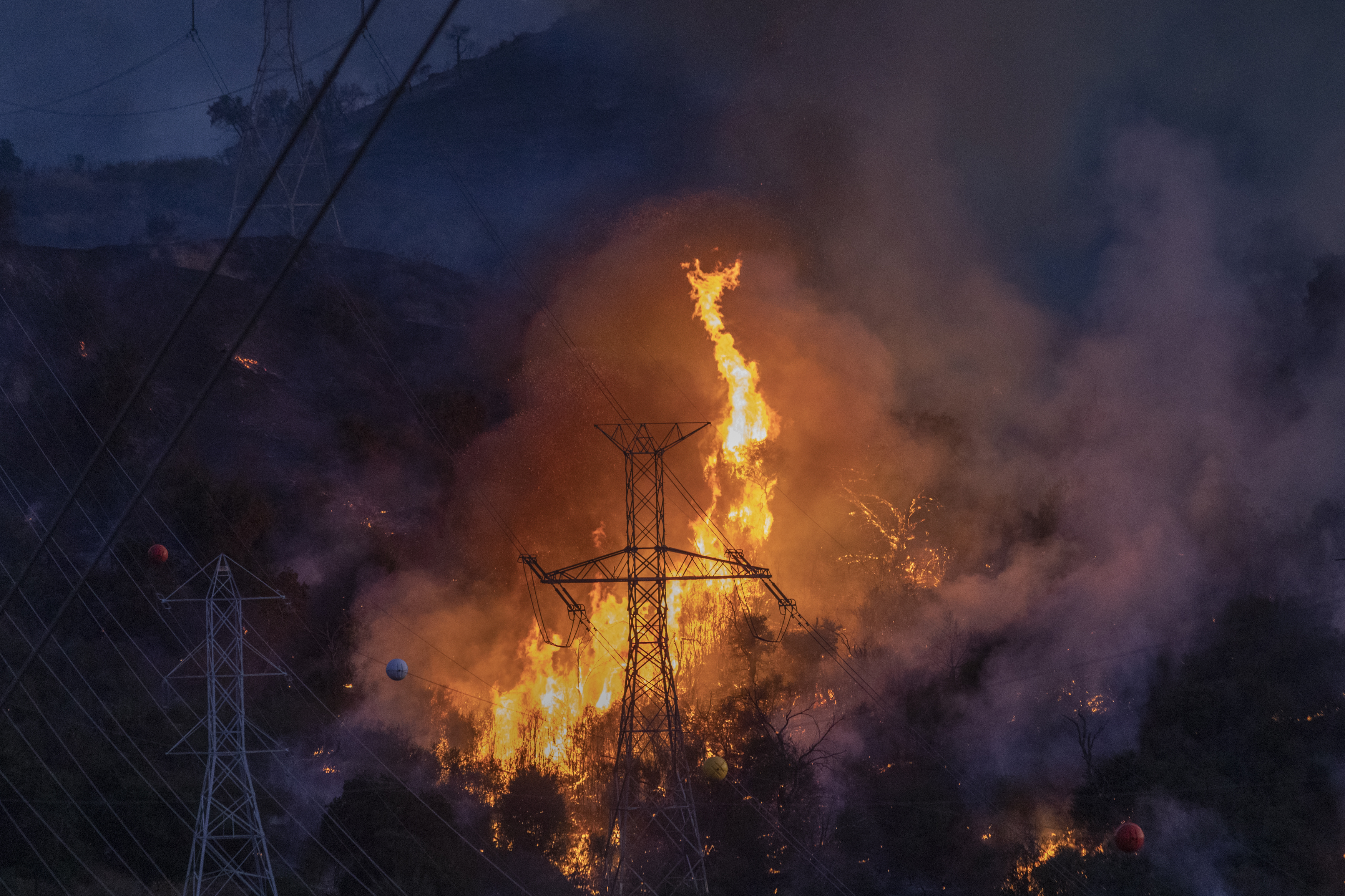 Flames heat up high power lines at the Saddleridge Fire on Oct. 11, 2019, near Newhall. (Credit: David McNew/Getty Images)