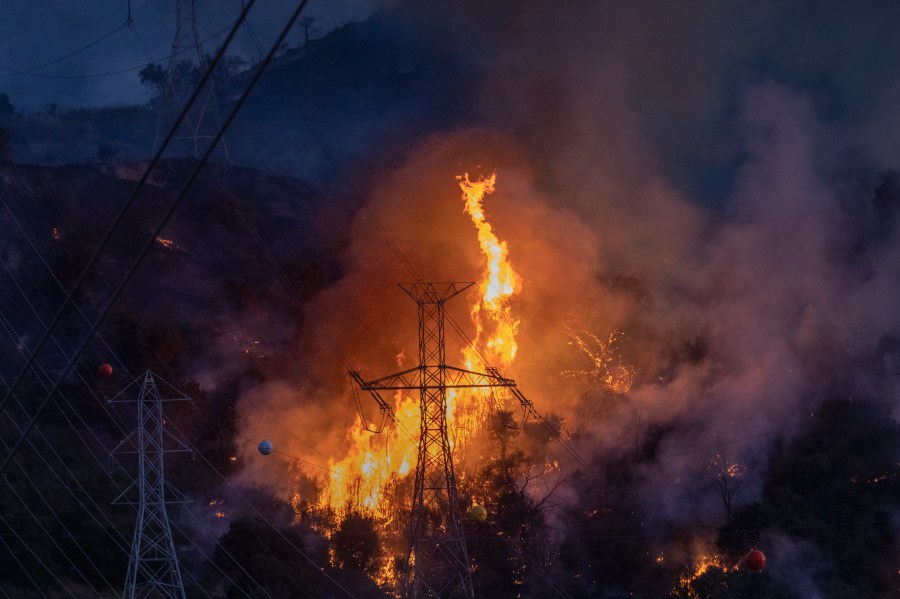 Flames heat up high power lines at the Saddleridge Fire on Oct. 11, 2019, near Newhall. (Credit: David McNew/Getty Images)