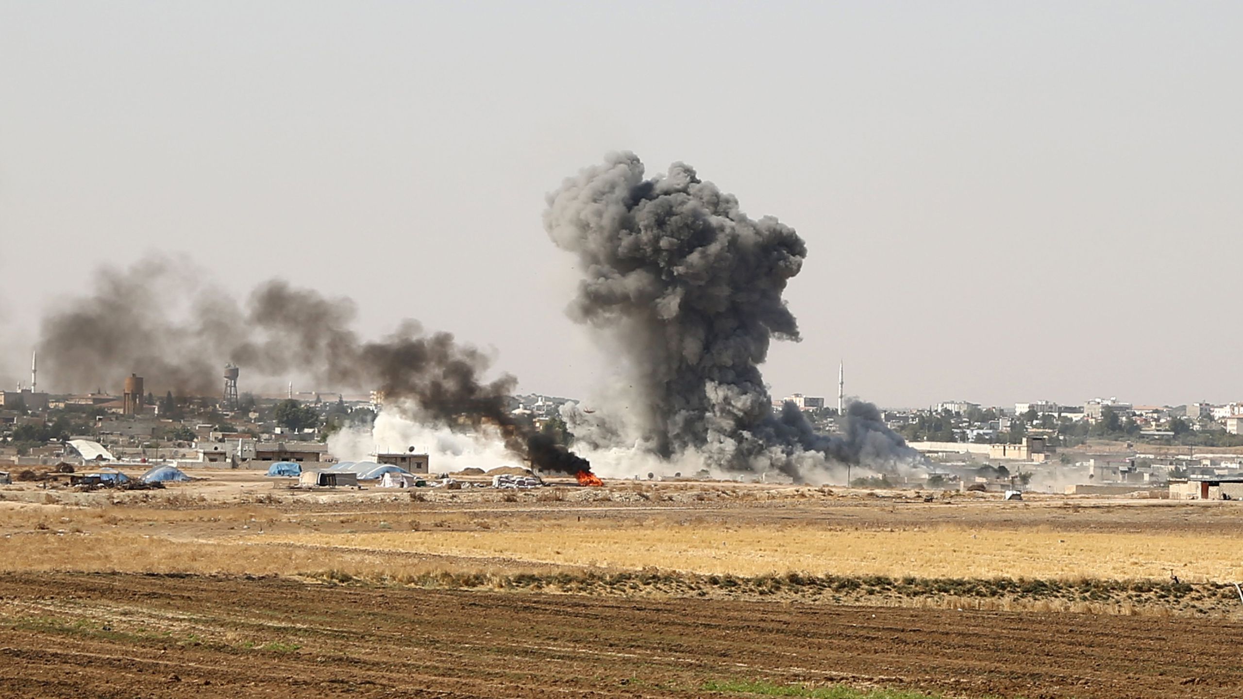 Smoke billows from the Syrian border town of Ras al-Ayn on Oct. 12, 2019, as Turkey and its allies continued their assault on Kurdish-held border towns in northeastern Syria. (Credit: Nazeer Al-khatib/ AFP via Getty Images)