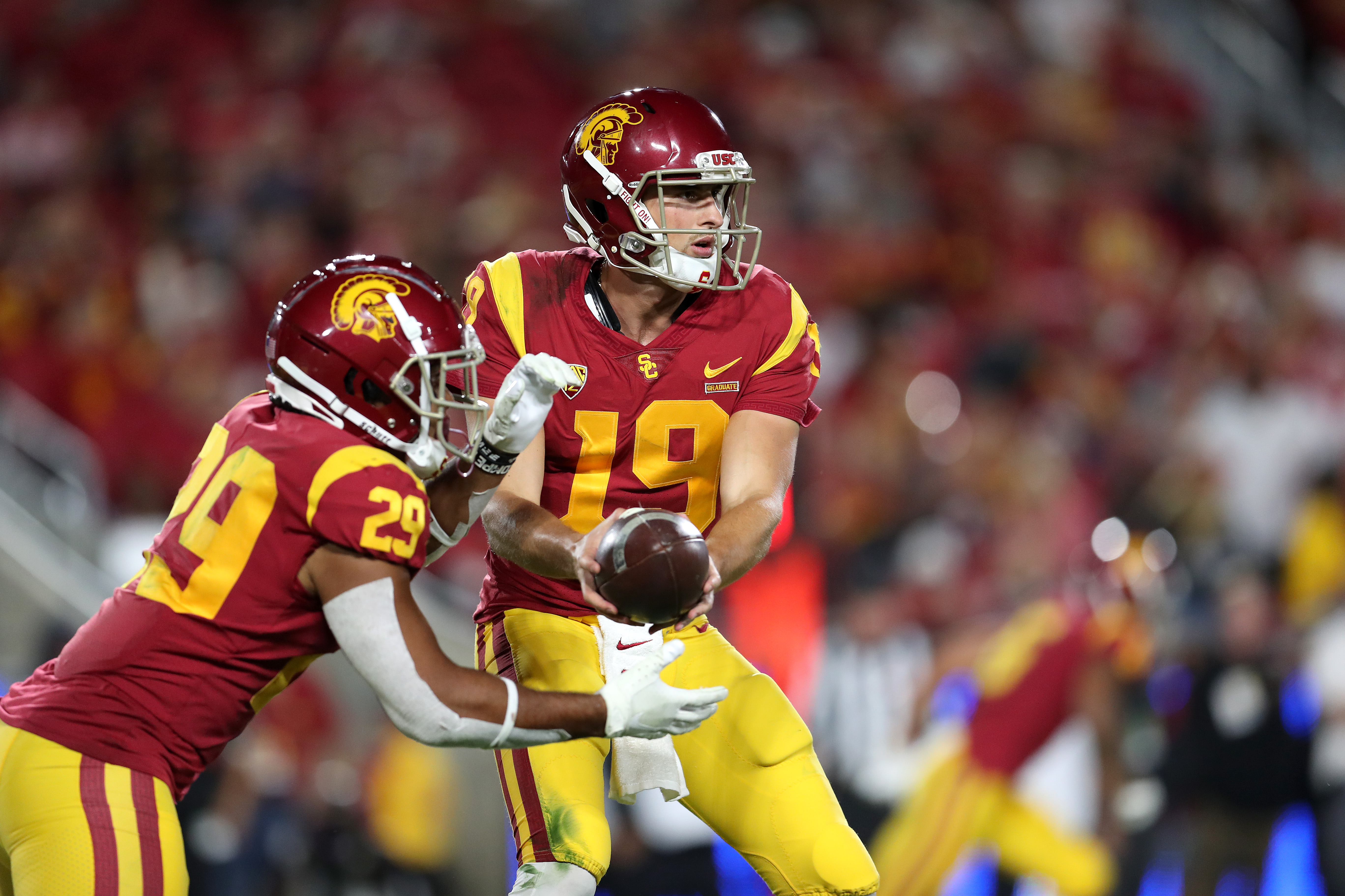 Matt Fink, No. 19, of the USC Trojans hands off to teammate Vavae Malepeai, No. 29, during a match against the Utah Utes at Los Angeles Memorial Coliseum on Sept. 20, 2019. (Credit: Meg Oliphant/Getty Images)