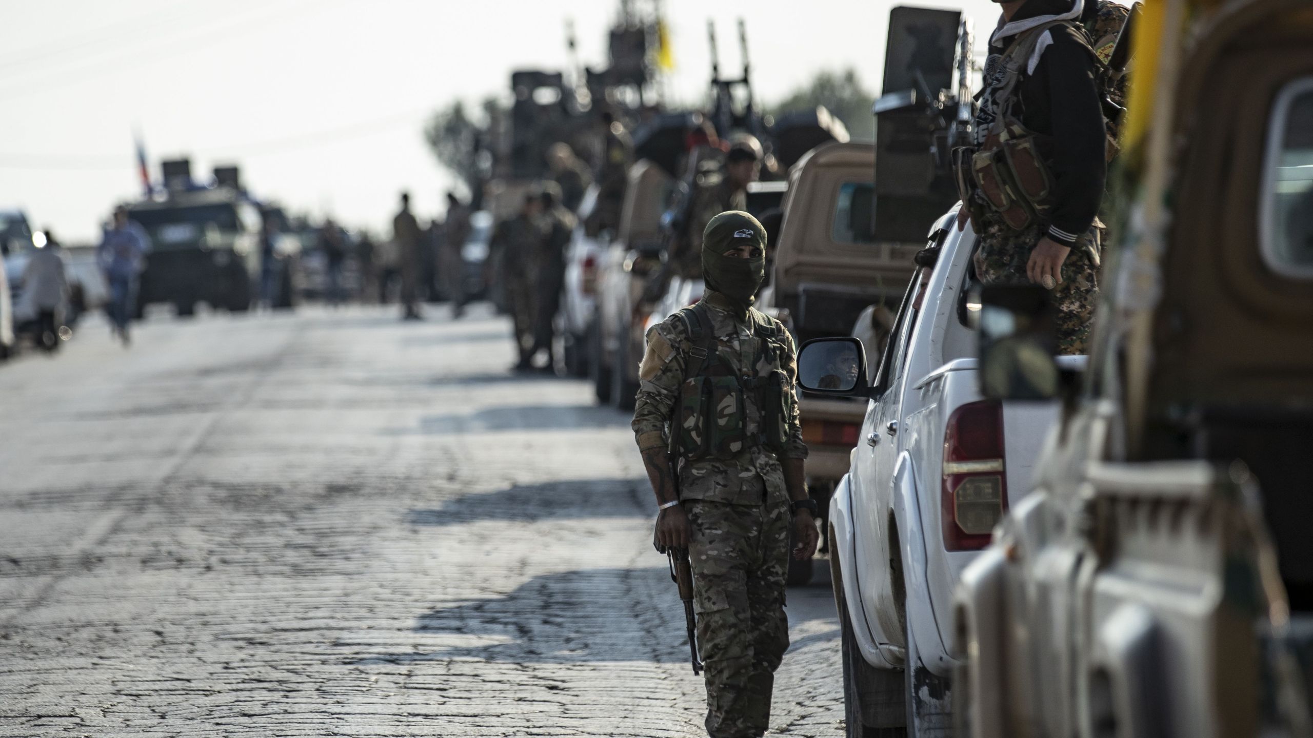 Fighters from the Syrian Democratic Forces gather in their military vehicles as they withdraw from the Sanjak Saadoun border area near the northern Syrian town of Amuda, on Oct. 27, 2019. (Credit: SOULEIMAN/AFP via Getty Images)