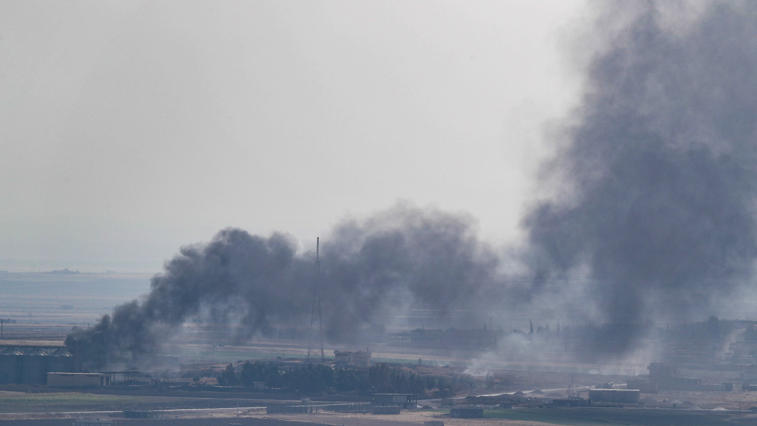 Smoke rises over the Syrian town of Ras al-Ain, as seen from the Turkish border town on October 18, 2019 in Ceylanpinar, Turkey. (Credit: Burak Kara/Getty Images)