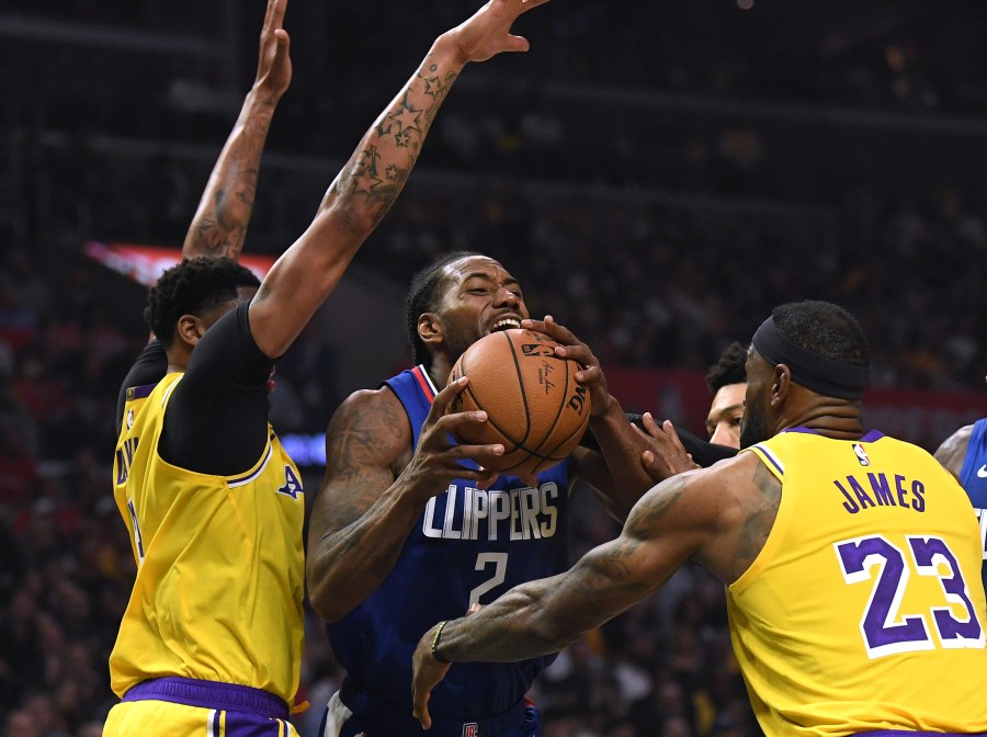 Kawhi Leonard of the L.A. Clippers is fouled by LeBron James of the L.A. Lakers as he steps by Anthony Davis during a game at Staples Center on Oct. 22, 2019. (Credit: Harry How/Getty Images)