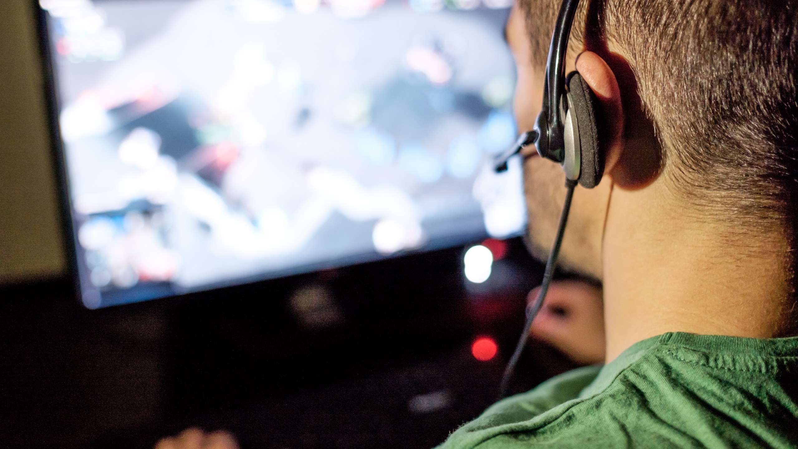 A man with headphones is seen playing video game in this file photo. (Credit: iStock / Getty Images Plus)