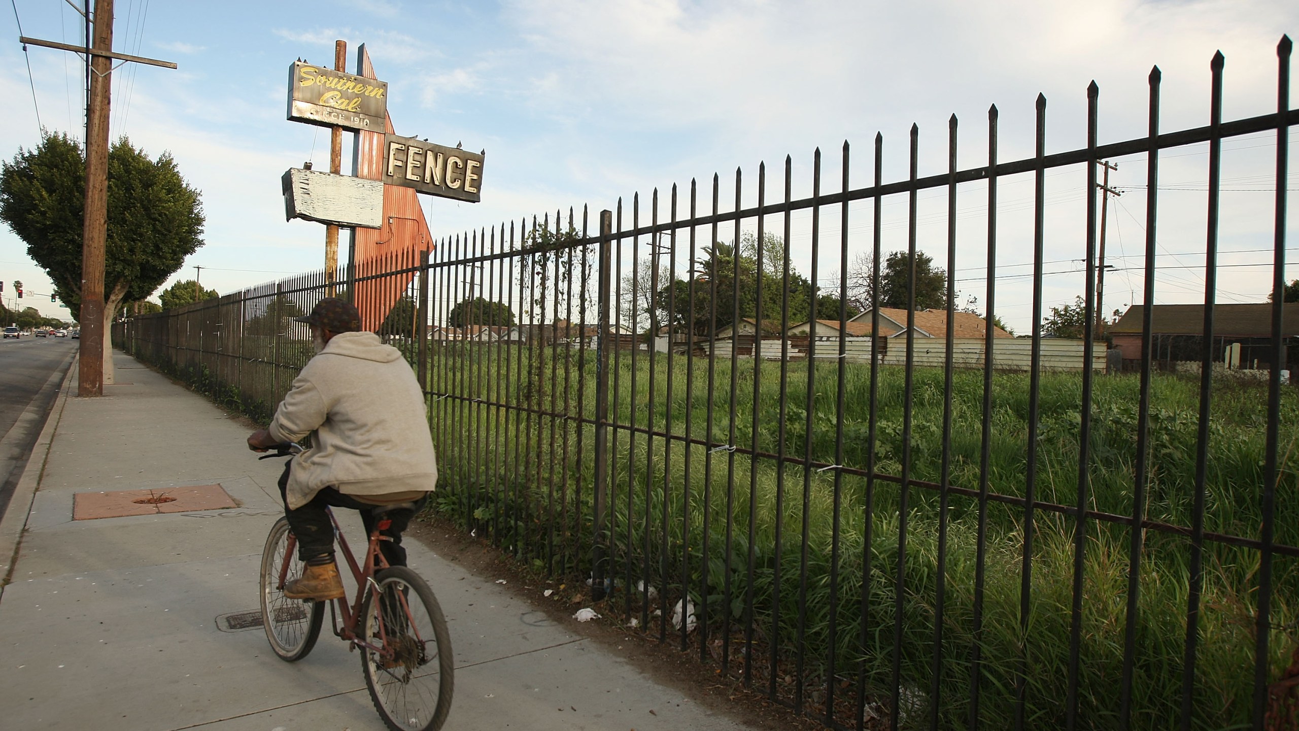 A man bicycles past a lot in Compton vacated years ago when a long-established business failed, on March 3, 2009. (Credit: David McNew / Getty Images)