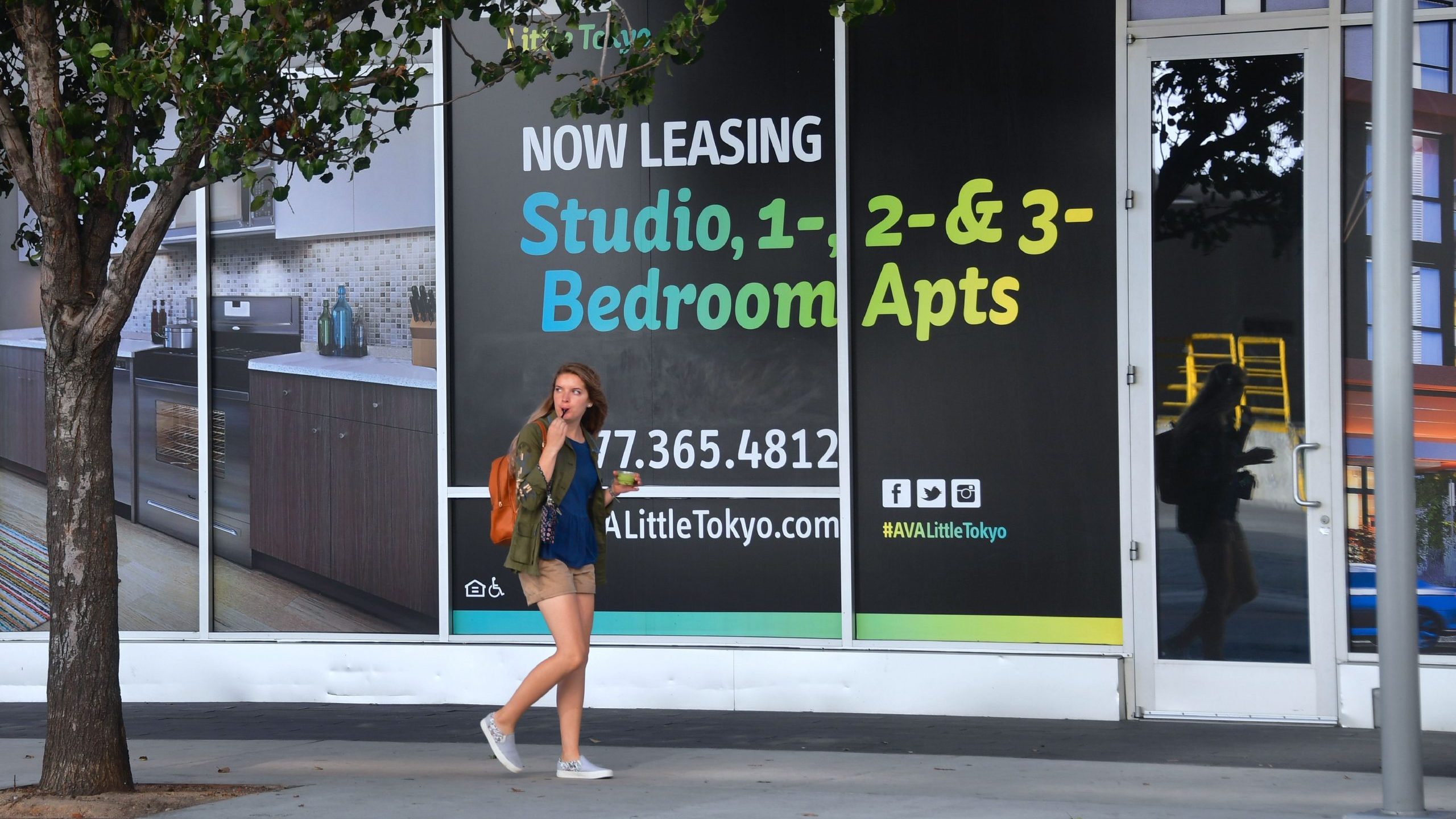 A pedestrian walks past advertising for new apartments in Los Angeles on Oct. 12, 2017. (Credit: Frederic J. Brown/AFP/Getty Images)