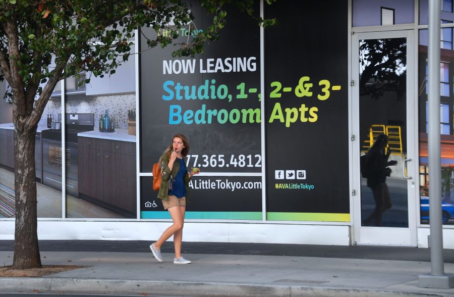 A pedestrian walks past advertising for new apartments in Los Angeles on Oct. 12, 2017. (Credit: Frederic J. Brown/AFP/Getty Images)