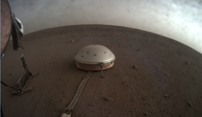 Clouds drift over the dome-covered seismometer, known as SEIS, belonging to NASA's InSight lander, on Mars. (Credit: NASA)