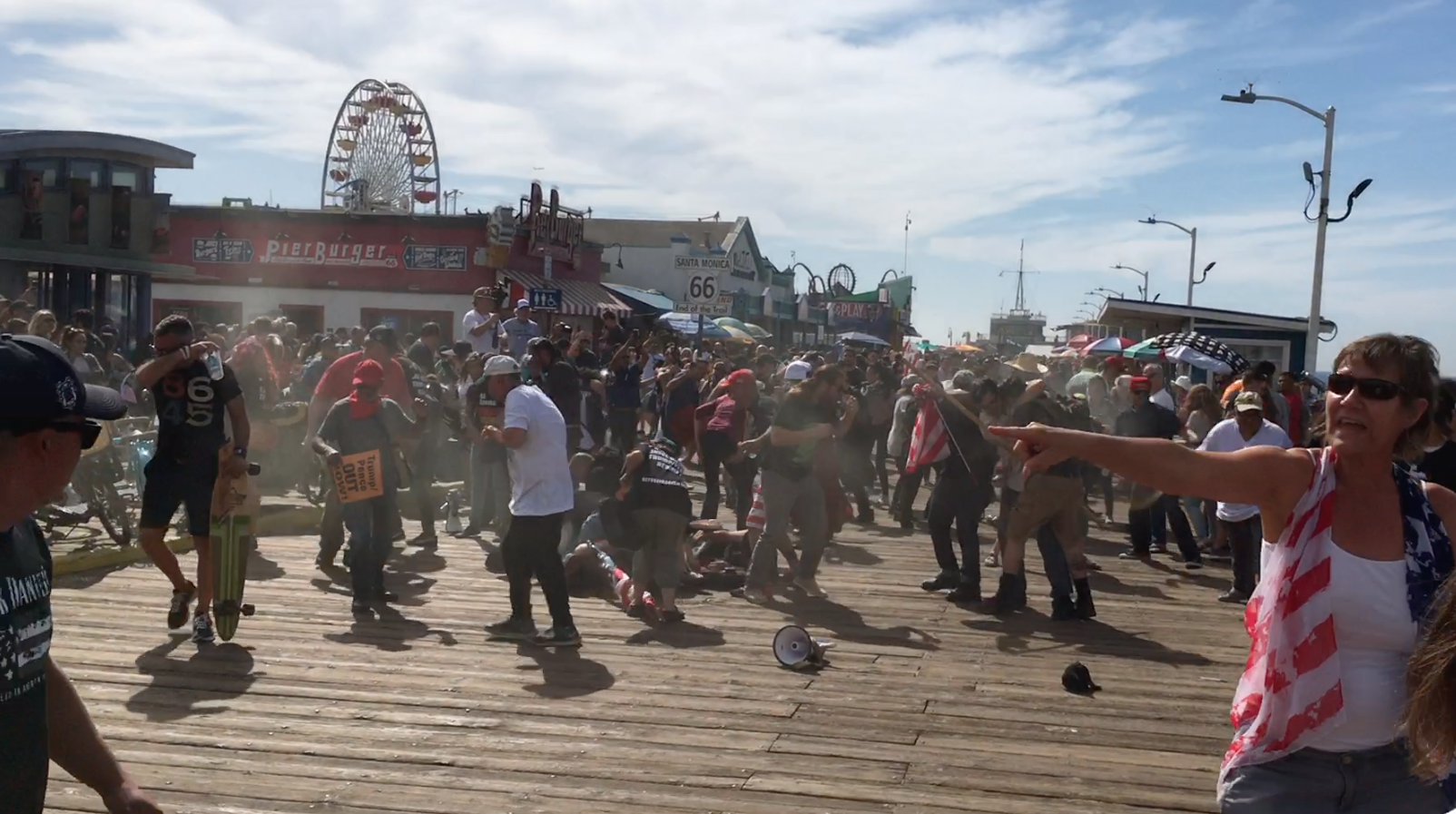 Screaming protestors disperse after what appears to be a cloud of pepper spray is seen in the crowd at Santa Monica Pier on Oct. 19, 2019. (Credit: KTLA)