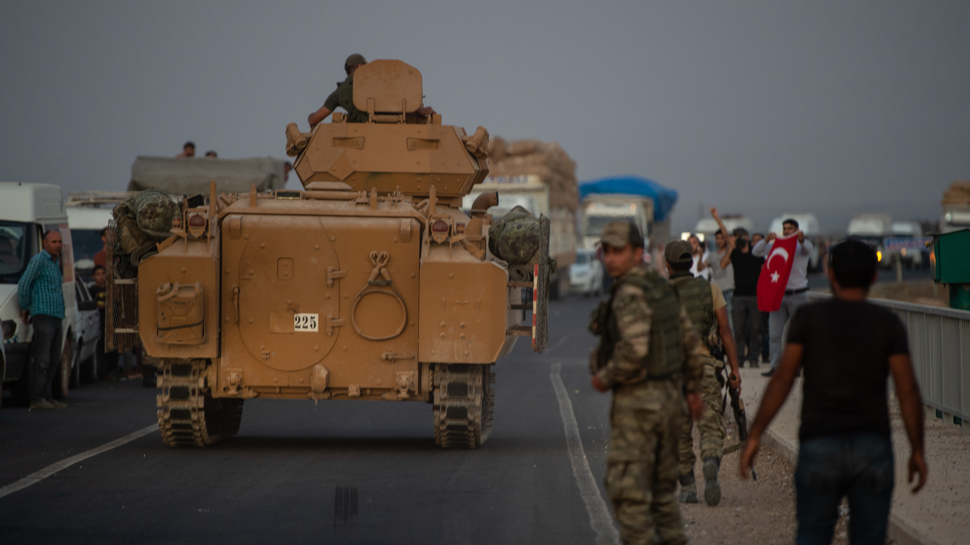 People wave as Turkish soldiers prepare to cross the border into Syria on October 09, 2019 in Akcakale, Turkey. The military action is part of a campaign to extend Turkish control of more of northern Syria, a large swath of which is currently held by Syrian Kurds, whom Turkey regards as a threat. (Credit: Burak Kara/Getty Images)